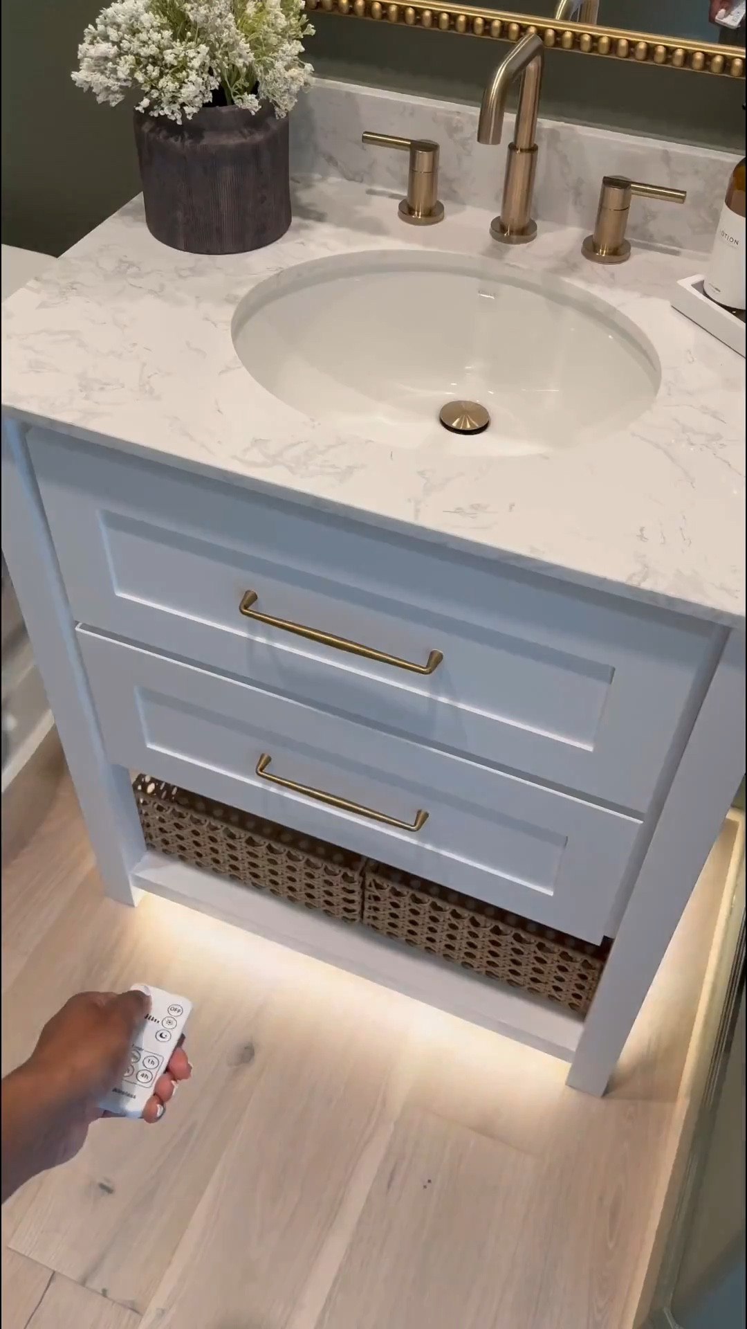 If you’re considering painting your powder room green, I’m telling you, THIS might be the perfect color for you … go for it! 

I used flat finish for the walls and painted the baseboards in satin finish… 

I’ll be honest, I was apprehensive at first … I even paintings the ceiling 😬 believe it our not, it made the room feel larger! 

I chose brass finishes bc I really wanted the space to have a vintage feel… well, modern vintage…??? If that’s a thing 😆.. 

The mirror is 30x40 inches… 

I added a new light fixture and it now faces upwards … which made that wall feel taller 

I wasn’t in love with this builder grade vanity tbh😆, matter-fact, I wanted to change it… it wasn’t functional …but now i wanna keep it lol 😂… I added brass hardware, these cute baskets from Walmart, led light strips on the bottom and now it’s a whole new unit….. you can even add battery powered/rechargeable/plug in led light strips .. whatever fits your lifestyle 

Ok let’s talk about this stunning planter!!! …. You know I love me an olive tree 😆… and I wanted something tell and slim… this planter was the perfect for plus it added to the moodiness 🥰

I am in love with this space… I wanted to create a vintage-cottagy feel in this powder room, while the rest of the home feels modern. #LTKVideo

#LTKHome #LTKStyleTip