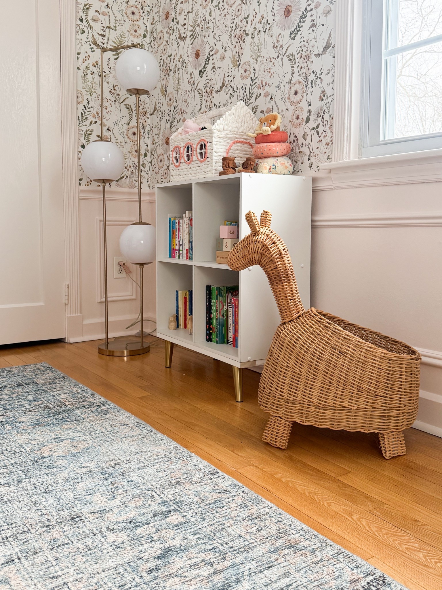 I love how this little corner mixes playful pieces with more classic elements in such an easy way. The woven giraffe adds that fun, whimsical touch, while the clean lined shelving and brass floor lamp keep everything feeling grounded and timeless. Even the floral wallpaper ties it all together with a soft pattern that makes the whole space feel warm and lived in.

nursery corner decor, kids room storage ideas, woven giraffe decor, rattan nursery accents, floral wallpaper nursery, neutral kids room design, brass floor lamp decor, kids bookshelf styling, cozy nursery corner, playful nursery details, modern classic nursery girlonthehudson

#LTKHome #LTKBaby #LTKKids