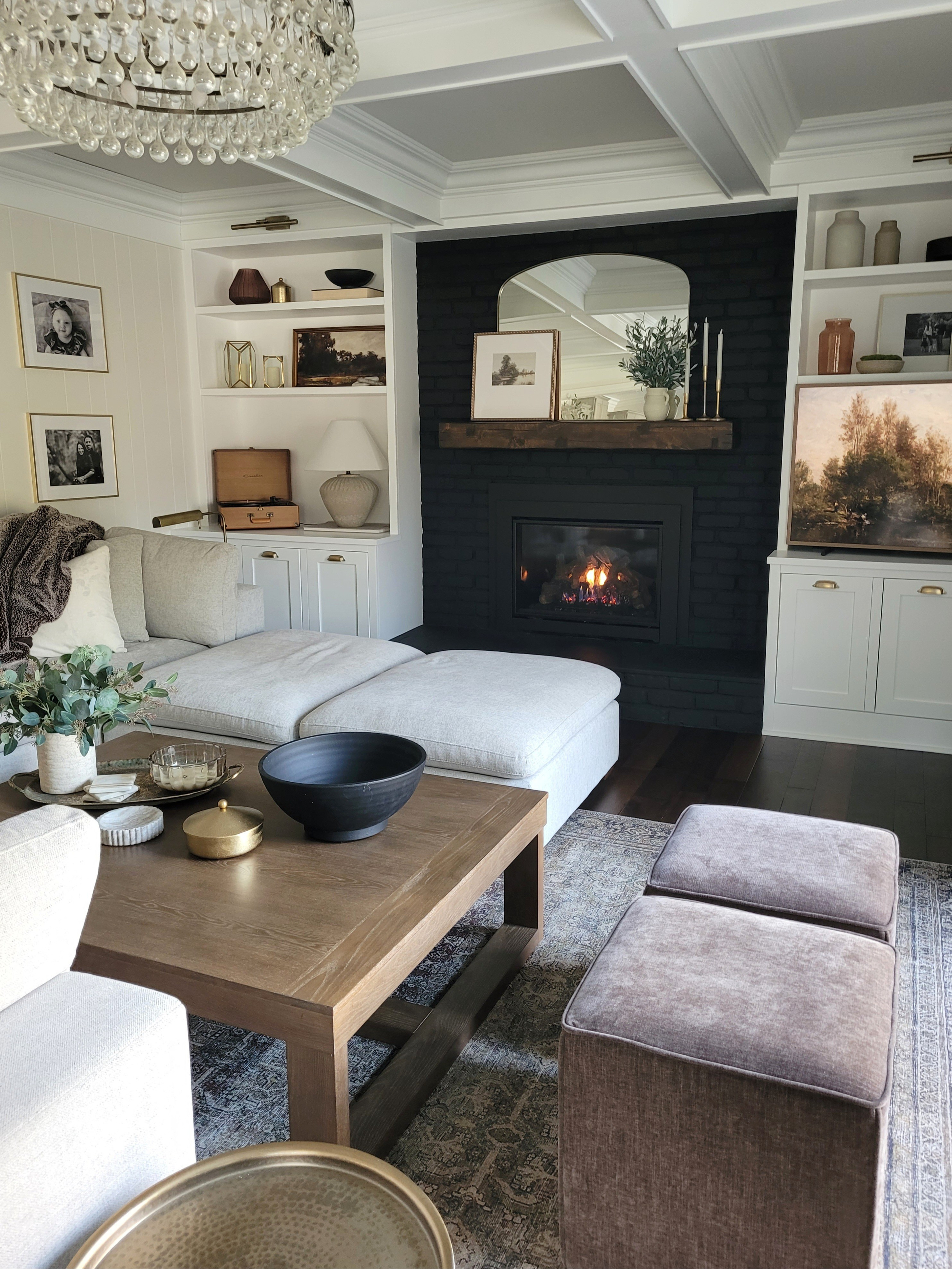 Cozy neutral living room family room with affordable coffee table, built ins, shelf styling,  upholstered ottomans,  drum side table,  pharmacy lamp,  mantle styling, coffee table styling,  vintage inspired art and rug, and sectional sofa! Lots of Amazon home finds!

#LTKHome #LTKFindsUnder50