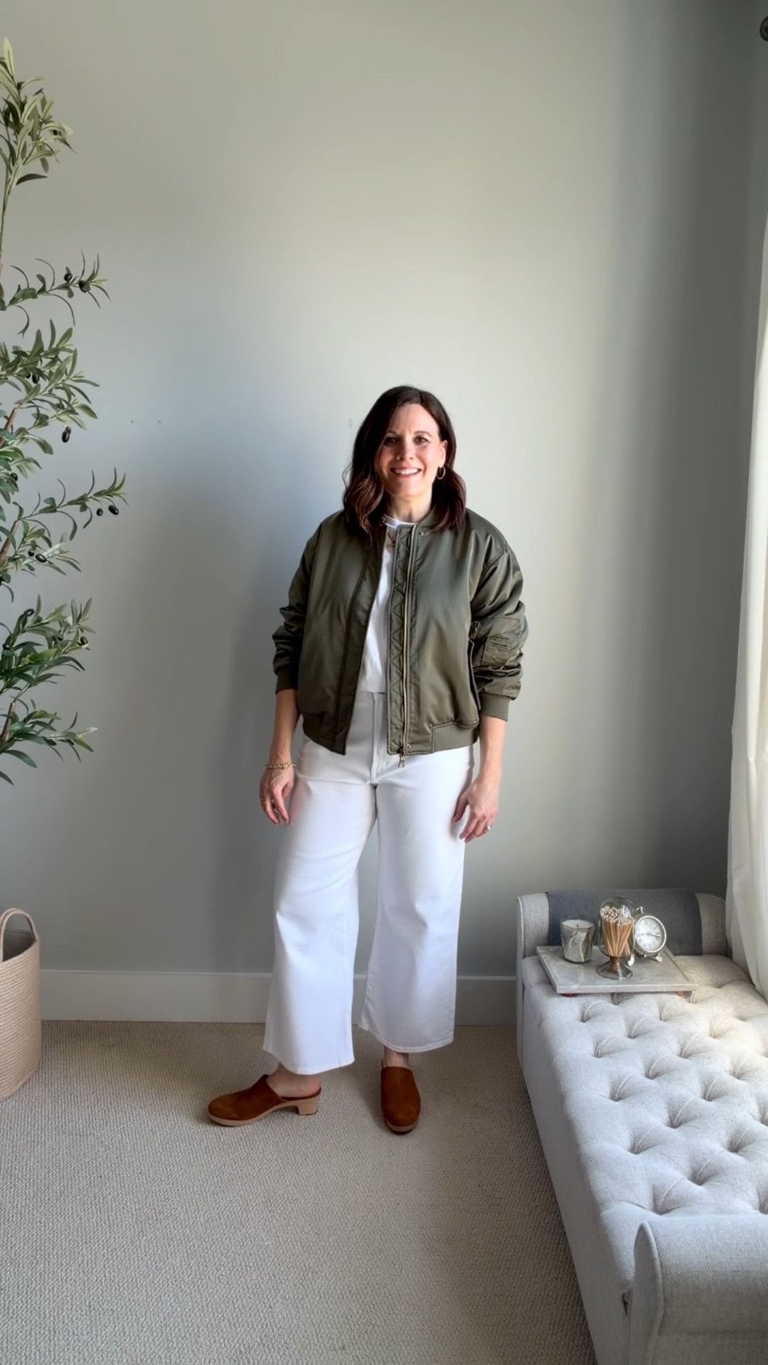 Here’s a look that works for transitional weather. I’m wearing simple wide leg cropped white jeans with a white tee, and brown clogs and this olive bomber jacket. The clogs and bomber jacket both add to the laid-back vibe of the outfit. Wear this for an easy dinner out.  These LOFT rivete wide leg jeans fit small in the regular fit. Size up. I’m in a small for this jacket.
#springoutfit2026

#LTKSaleAlert #LTKOver40 #LTKMidsize