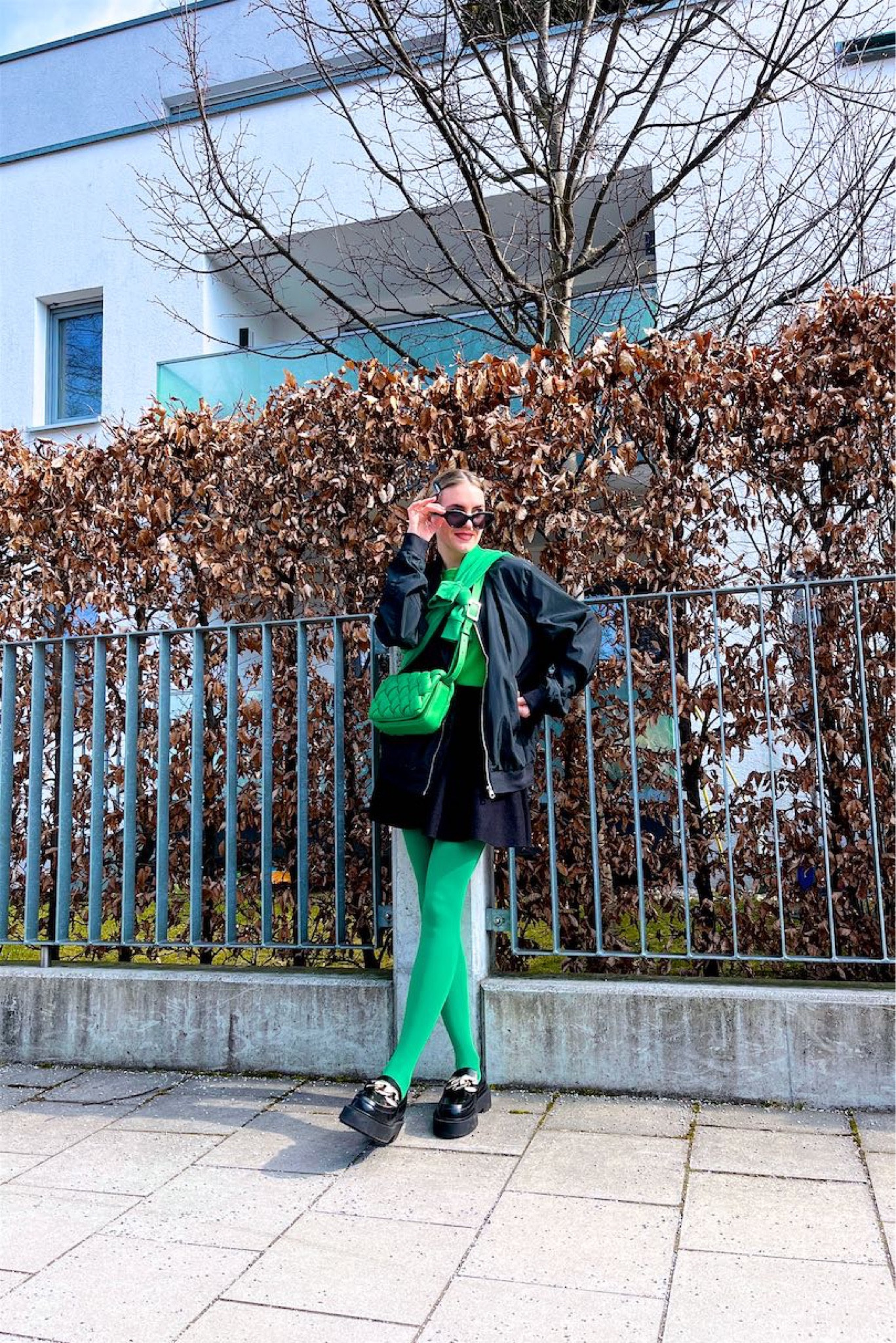 Bomber Jacket. Fashion Blogger Girl by Style Blog Heartfelt Hunt. Girl with blond sleek bun wearing a bomber jacket, green sweatshirt, black skirt, green braided bag, green colorful tights and chunky loafers. #colorfuloutfit #colorfulstyle #colorfulfashion #colorfullooks #fashionfun #cutespringoutfit #springfashion2023 #springlookbook #fitcheck #dailylooks #dailylookbook #contentcreator #microinfluencer #discoverunder20k