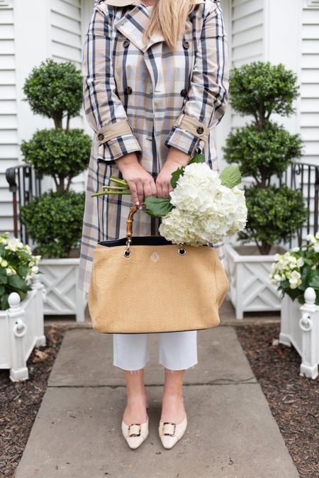 Spring outfit details 🤍 (Bag on SALE) Plaid trench coat, white high rise boot flare jeans, Swiss dot ruffled tank, neutral patent leather heels with a tortoise shell buckle, & a really great everyday bag in raffia with a bamboo handle. Faux Boxwoods and planters linked too.

#springoutfit #mothersdaygift #womenswhitejeans #ladiestrenchcoat 

#LTKFind #LTKitbag #LTKsalealert