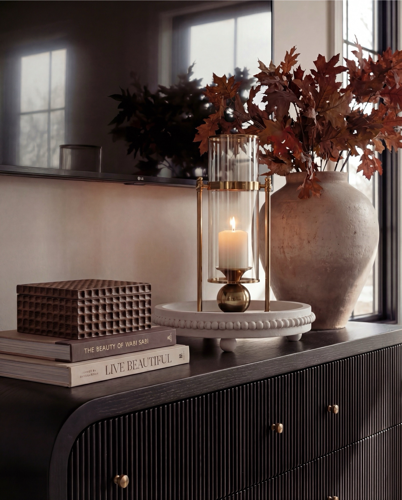 Shop the Look:
• White upholstered wingback bed frame
• White cotton duvet cover + pillow shams
• Textured throw pillows (rust + black patterned)
• Chunky knit throw blanket (warm brown)
• Vintage-style brown area rug
• Dark wood nightstands with brass knobs
• Ceramic table lamp (neutral glaze)
• Brass globe wall sconces
• Framed floral artwork (muted tones)
• Arched brass wall mirrors
• Upholstered bench at foot of bed (camel brown)
• Cream accent chair with wood arms
• Black fluted dresser with brass pulls
•Ceramic beige decor bowl
•Decor wood beads 
•Decor book
• Large ceramic floor table vase (earthy clay tone)
• Decorative wood bead garland
• Sheer white curtain panels
•Decor tray
•Hurricane candle holder
Wood Jewelery box 

#LTKSaleAlert #LTKHome