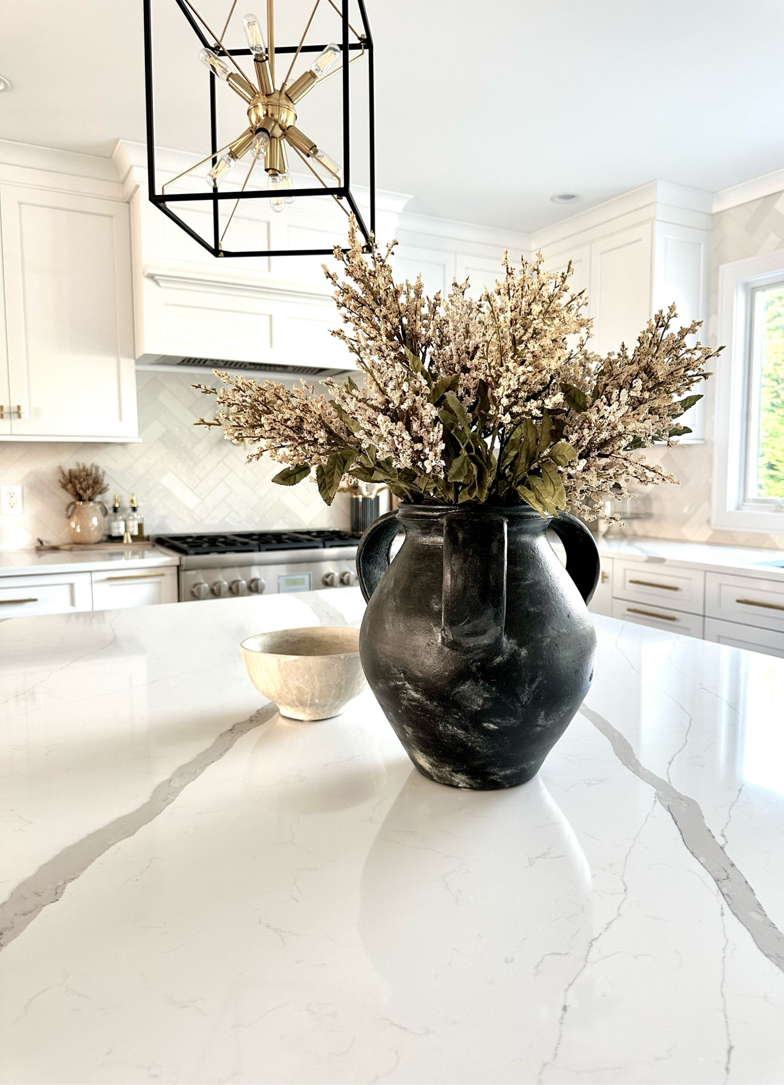 Fall home decor, autumn styling, cream Heather bush fall floral stems, black Joshua ceramic urn vase pottery barn, artisan cream bowl, beige ceramic vase, tan berry bundle fall floral, glass olive oil bottles, black gold pendant lantern light, cloe backsplash tile, kitchen inspo 

#LTKhome #LTKSeasonal
