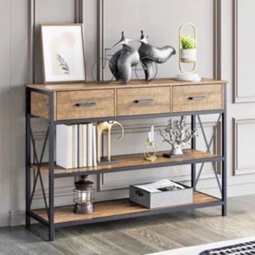 This wood-look console table from Wayfair has that layered, collected look I love for an entryway or living room wall. The three drawers keep the little everyday things tucked away, while the two open shelves give you plenty of room for books, baskets, and decor. The black metal frame and X-side details add a nice contrast to the warm wood finish. Styled with leaning framed art, sculptural objects, a small mirror, books, a lantern, and a storage box, it feels finished without being fussy.

#LTKSaleAlert #LTKHome