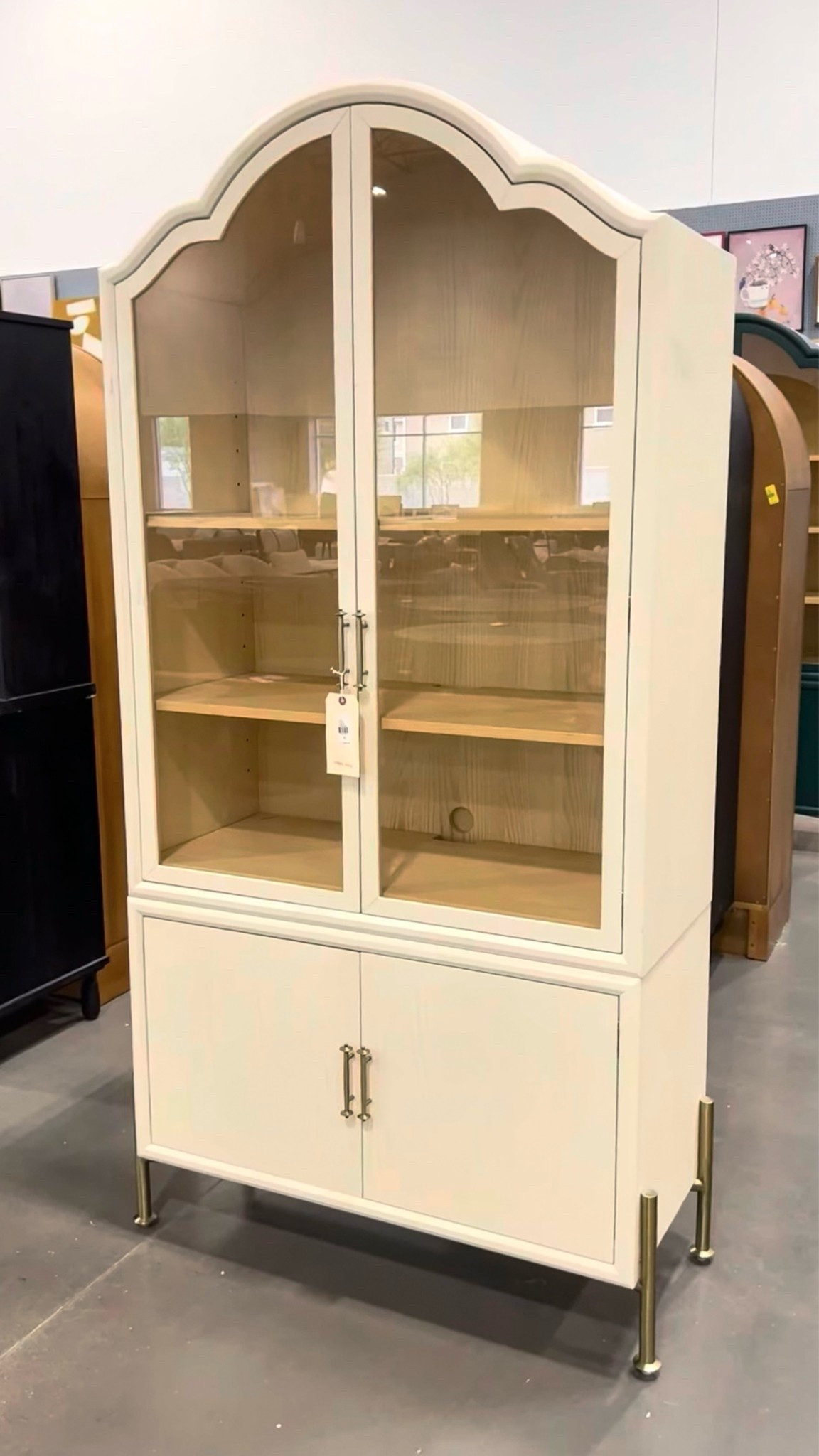 Elegant display cabinet inspo! 🤩 The Livia Glass & Wood Storage Hutch from Anthropologie is such a beautiful statement piece with its arched silhouette, glass doors, and off-white finish. 🤍 Perfect for displaying dishes, decor, books, or collected pieces while adding an elevated look to the space. 💫 Love that it also comes in two sizes — a taller 94” height option and a smaller 78” height version depending on your space. Such a timeless, sophisticated piece. Linked it here! ✨#AnthroHome #DisplayCabinet #ArchedCabinet

#LTKHome #LTKSaleAlert