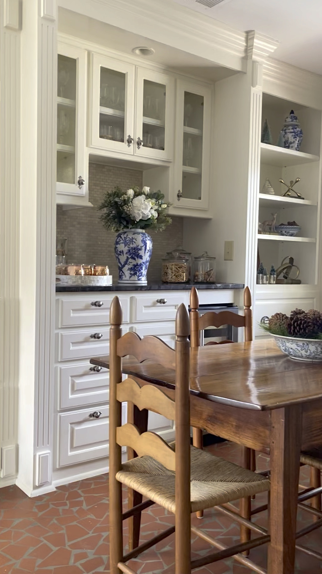 This little nook is the heart of our family room, masquerading as a culinary corner. It's where our dry bar stands proud and shelves brim with memories. Added charm from a bygone era with those iconic red tiles underfoot. 🤍

#LTKVideo #LTKstyletip #LTKhome