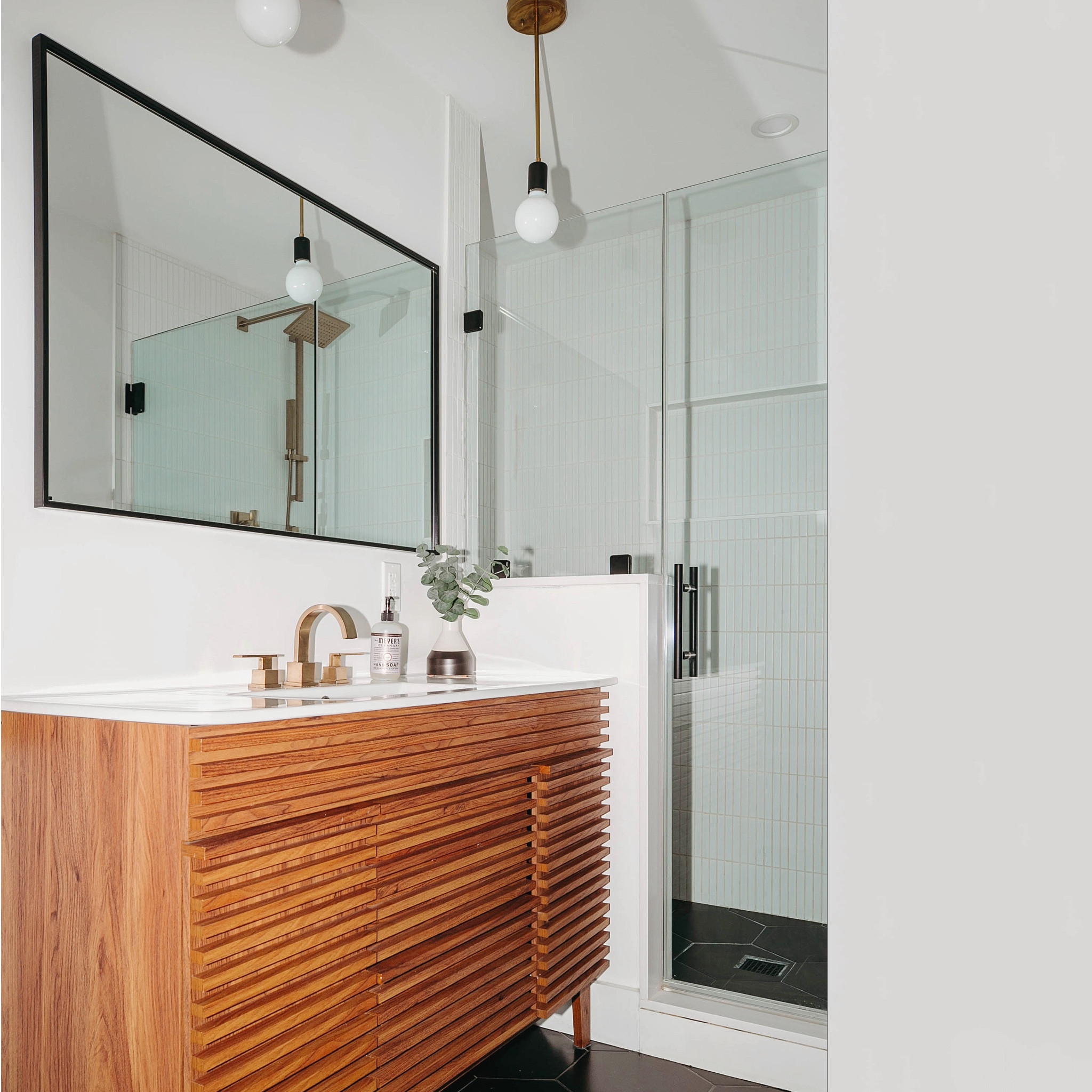 every room in this mid-century modern fixer-upper impressed us with great bones, and the primary bathroom was no exception! the original layout was very efficient, so we kept everything in the same place, but enlarged the shower to accommodate a bench. our #dwelloctoberstudio cosmetic updates gravitated to a neutral palette with black hexagon floor tile, stacked white kitkat wall tile, a walnut wood vanity, and gold plumbing fixtures. #dwelloctoberrealestate #dwelloctober

#LTKhome