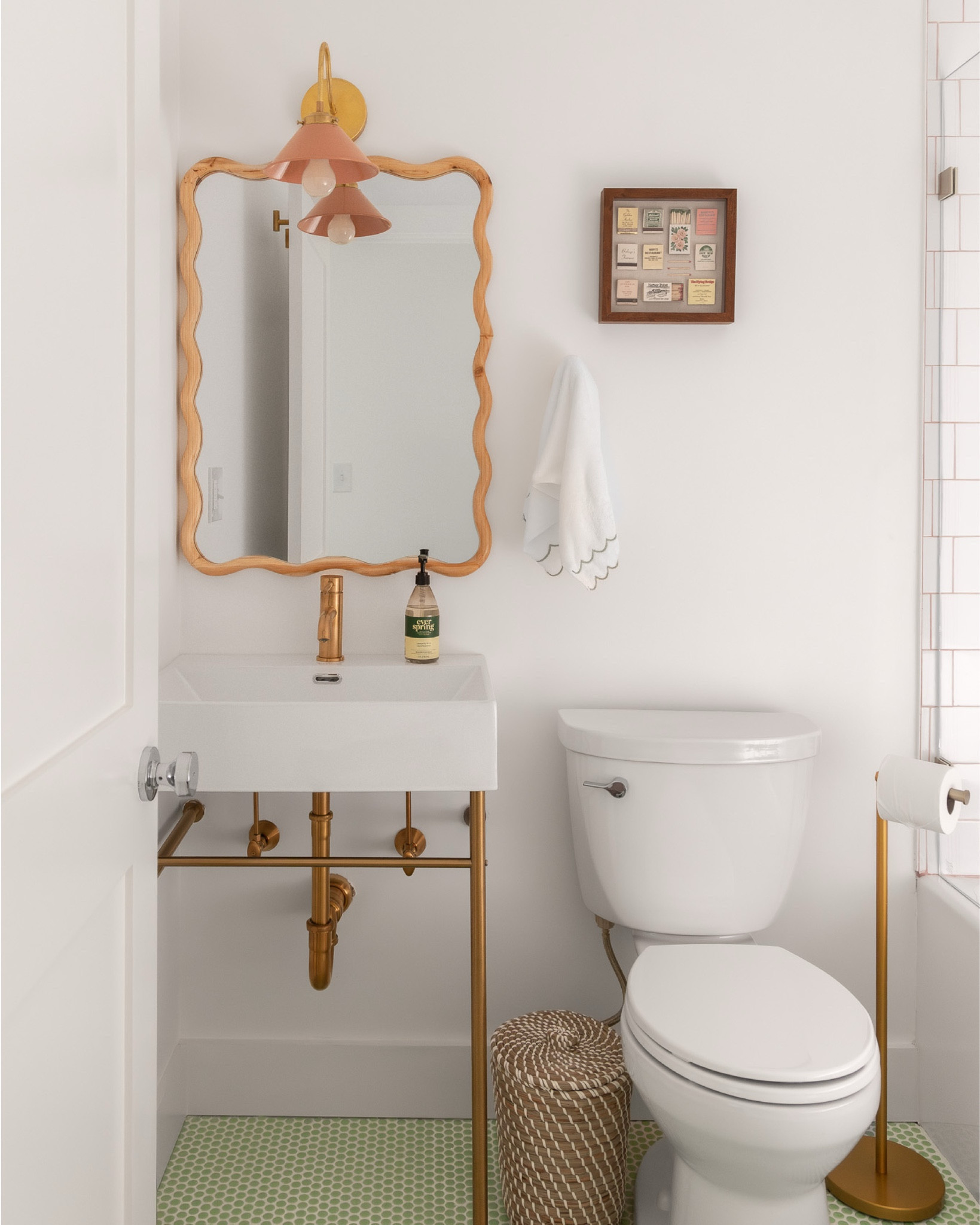 located off the main hallway, the guest bathroom at the #preppyhollowhouse was an interior bathroom, meaning that it had no windows and therefore, no natural light. as a result, we aimed to create a bold and bright design full of color in order to give the space a playful personality. we opted for green penny tile on the floors and simple white field tile on the walls, but used coral grout to make a statement. brushed gold plumbing fixtures, a console sink, and a wavy wooden wall mirror give the space a colorful, cheerful feel. #dwelloctoberstay #dwelloctober

#LTKHome