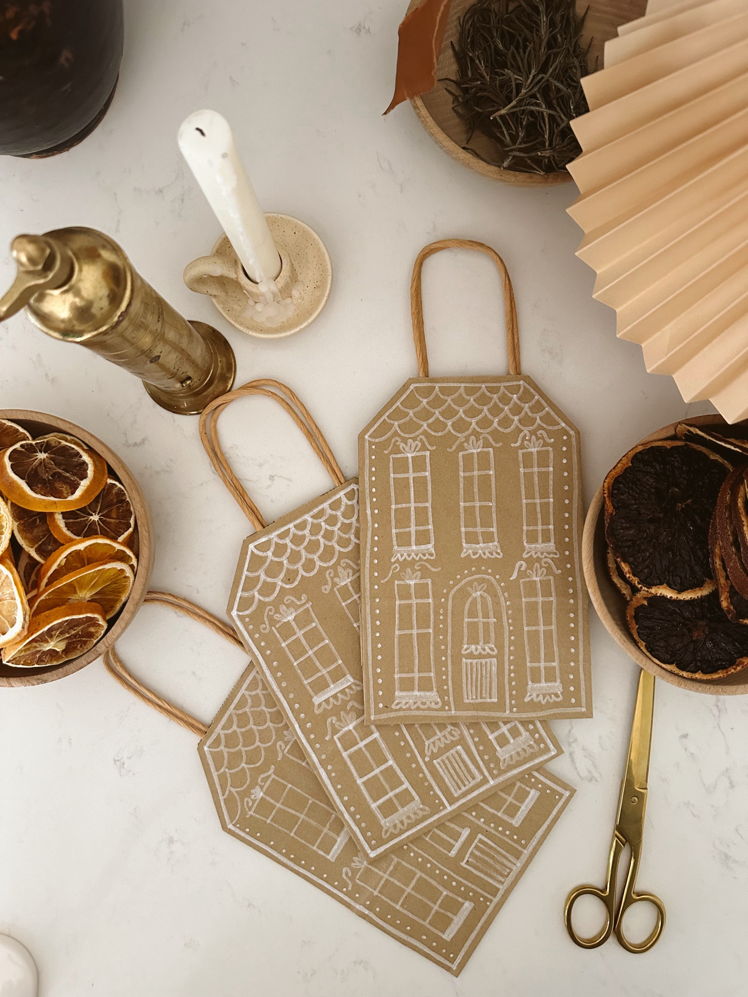 easy diy gingerbread house gift bags! All you need are kraft paper bags, white paint pens and a pair of scissors  

#LTKGiftGuide #LTKHoliday #LTKSeasonal