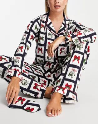 Chelsea Peers top and pants pajama set with eyemask and scrunchie in christmas stamp print | ASOS (Global)