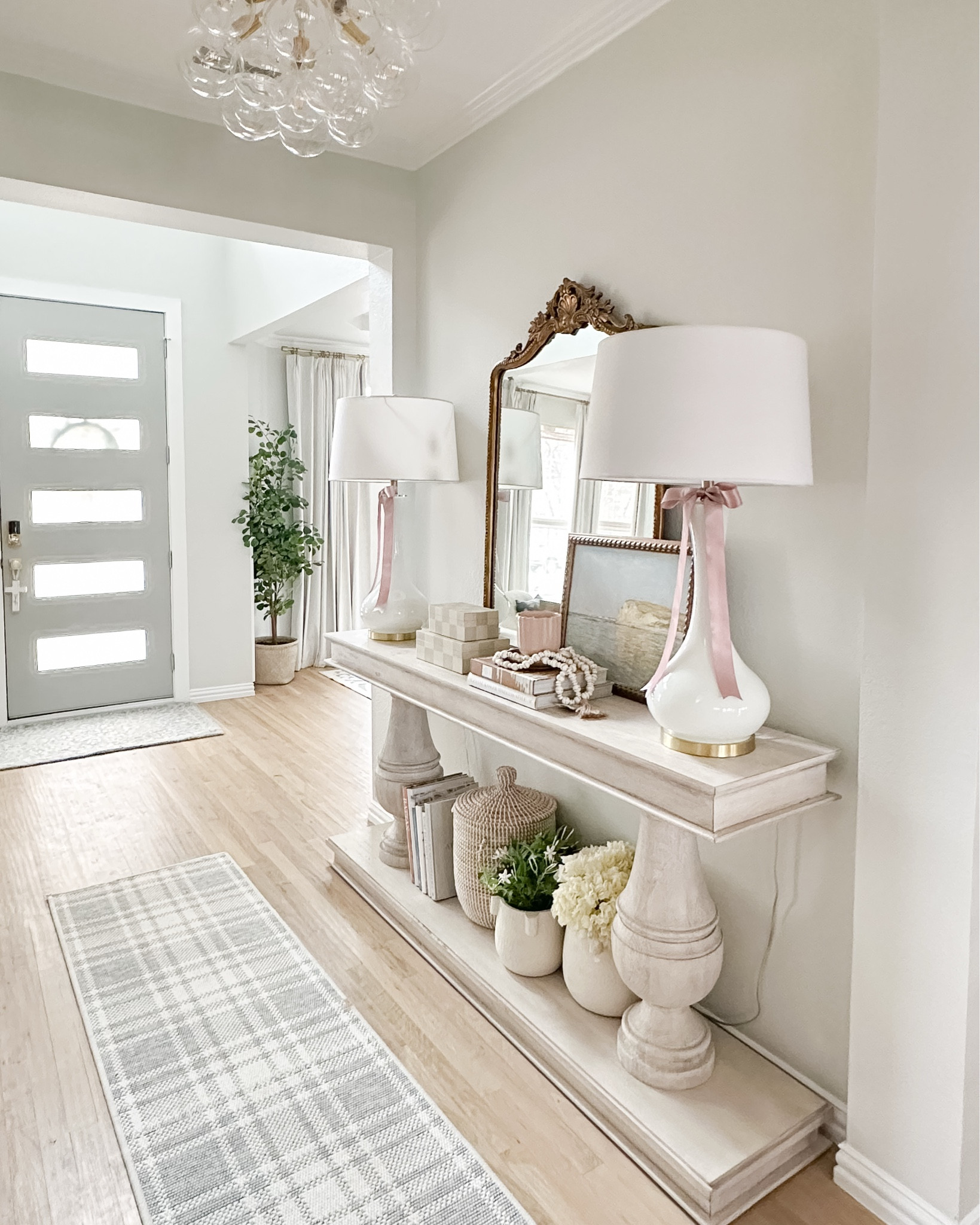 Entryway Hallway console table, front door with windows, barn door, gold barn door hardware, white lamps, 