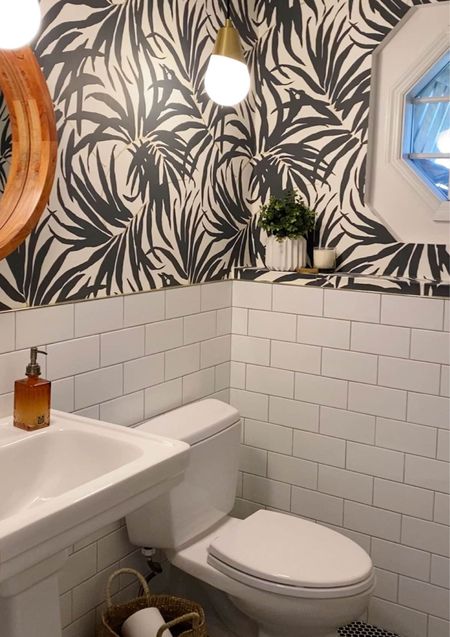 Modern black and white bathroom - affordable palm frond removable wallpaper, brass pendant lights, round wood mirror. 

#LTKFind #LTKhome