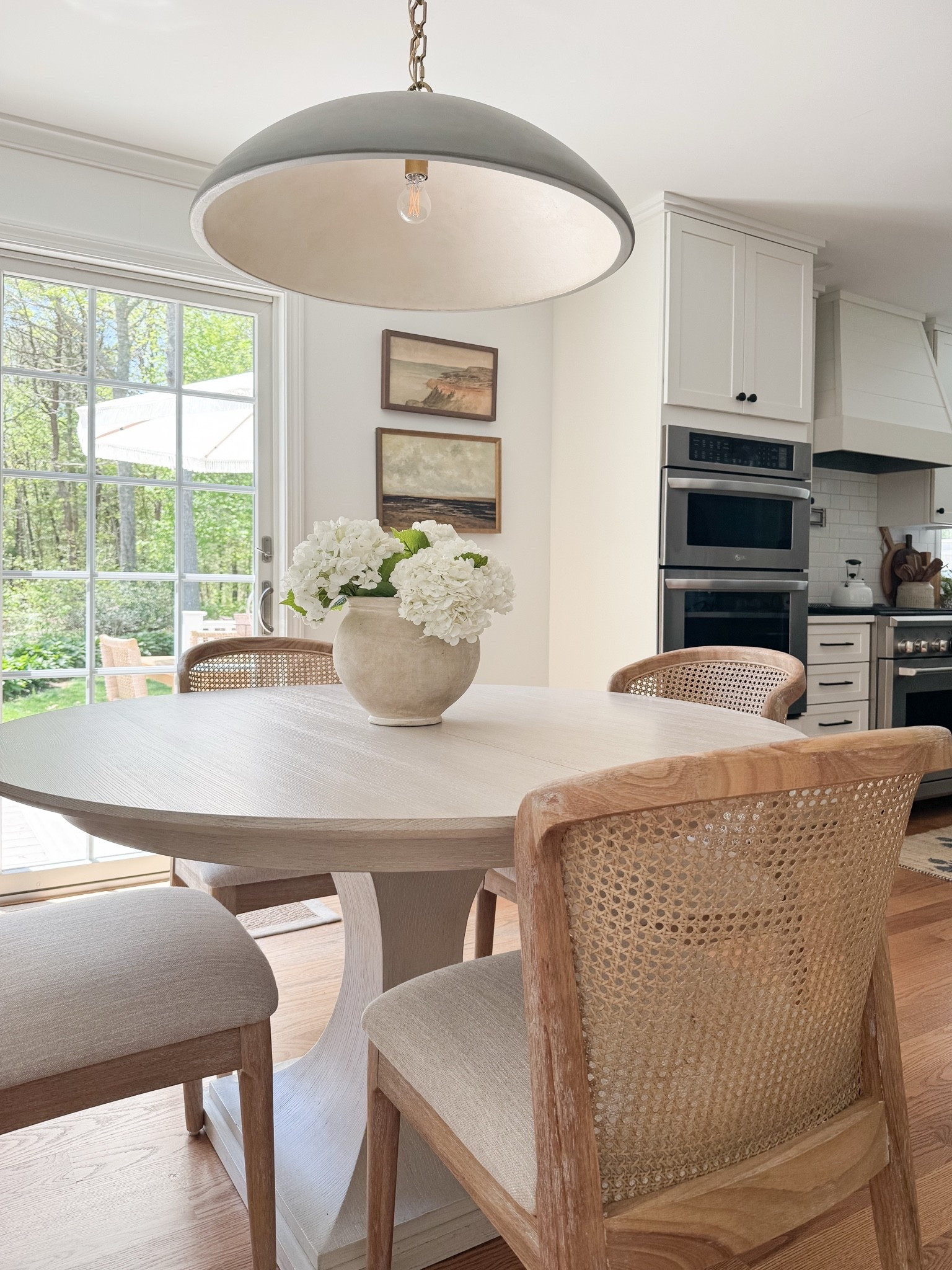 Coastal dining room styled with round wood table, woven dining chairs, faux hydrangeas, and soft natural light for relaxed coastal dining.

coastal dining room decor, round wood dining table, woven dining chairs, faux hydrangea centerpiece, neutral dining room styling, coastal interior decor, light coastal home, neutral dining room inspiration, sherricalnanhome

#LTKHome