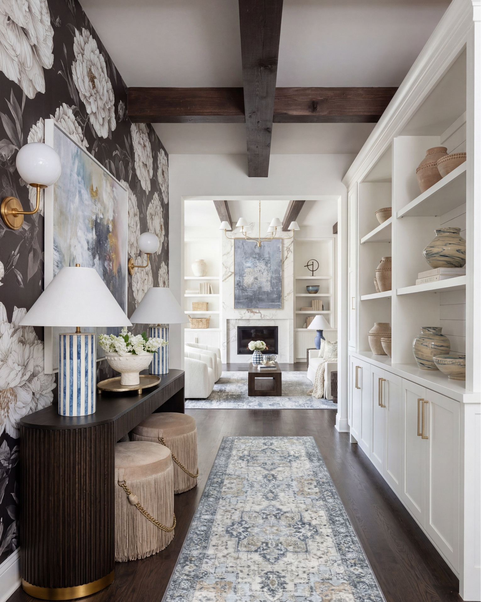 Layered transitional living room inspiration with luxe marble fireplaces, moody floral wallpaper, dark wood beams, boucle accent chairs, and designer lighting details. Shop the look for a cozy modern organic home with high-end furniture, neutral decor, blue accents, brass lighting, textured rugs, and timeless statement pieces. Perfect inspiration for anyone searching for transitional style living rooms, modern farmhouse decor, marble fireplace ideas, designer coffee tables, and curated home accessories. 

Shop this space: • Marble fireplace surround • Dark wood ceiling beams • Brass chandelier lighting • Boucle accent chairs • White slipcovered sofa • Blue patterned throw pillows • Dark wood coffee table • Abstract framed artwork • Textured neutral area rug • Ceramic table lamps • Built-in shelving decor • Decorative woven baskets • Floral wallpaper mural • Fringe ottomans • Fluted console table • Brass wall sconces • Ribbed cabinetry details • Marble slab backsplash • Glass cabinet fronts • Wine fridge built-in • Blue and cream vintage style rug • Modern ceramic vases • Coffee table styling books • Neutral cozy throw blankets

#LTKsale #LTKhome #LTKstyletip