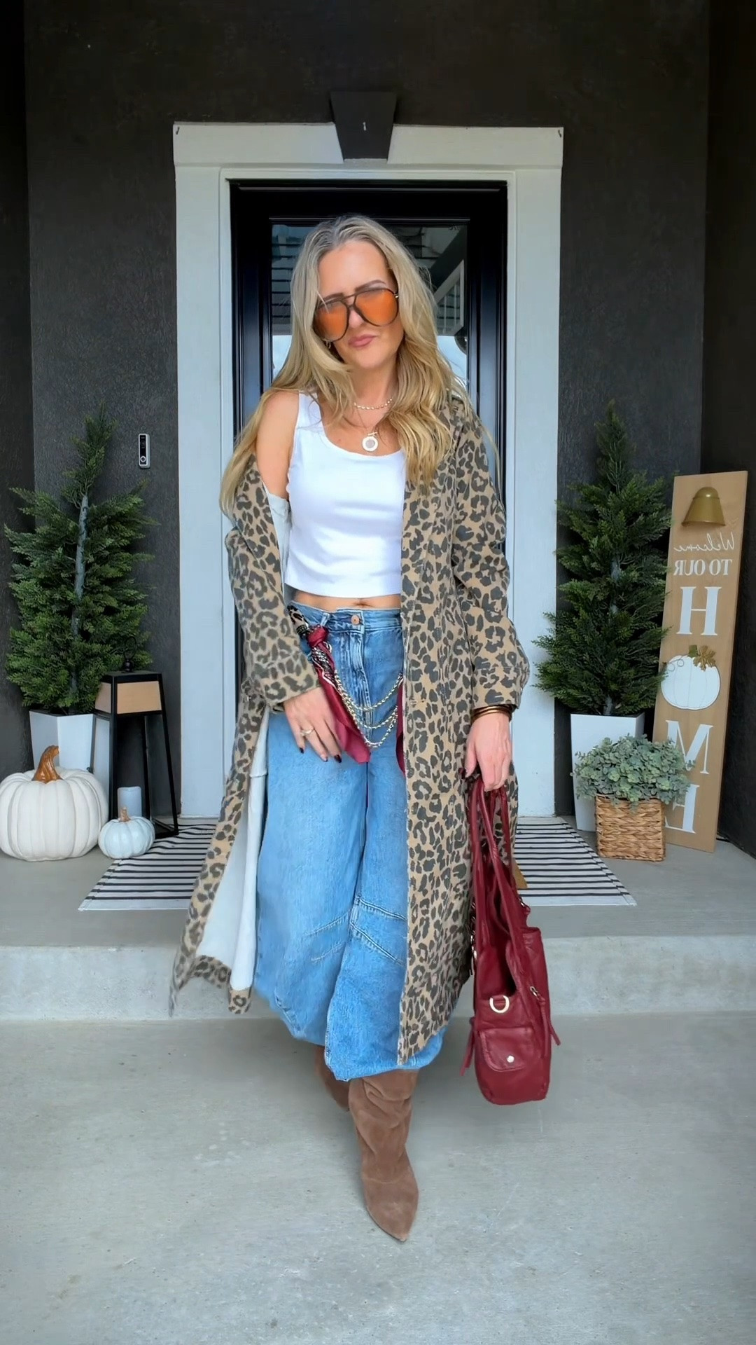 Elevated casual outfit with blue barrel jeans, a white crop top, and a long cheetah print jacket doing all the talking. Slouchy suede kitten-heel boots, a red scarf belt, gold chain details, red bag, and aviator sunglasses give the whole look that bold, cool-mom energy without losing the easy jeans-and-a-top feel. 

 #LTKootd #LTKOver40 #LTKPetite