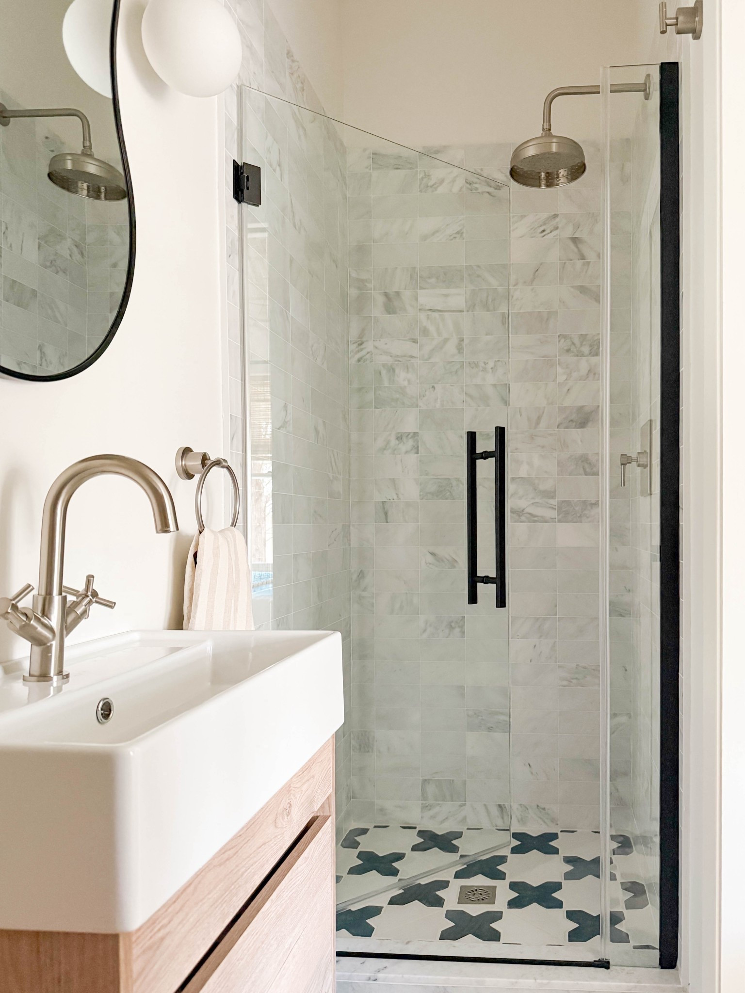 in this guest bath, we mixed black and brushed nickel with blue and gray tiles. The wood vanity provides a pop of warmth and is such a great slim size for a narrow bathroom like this one