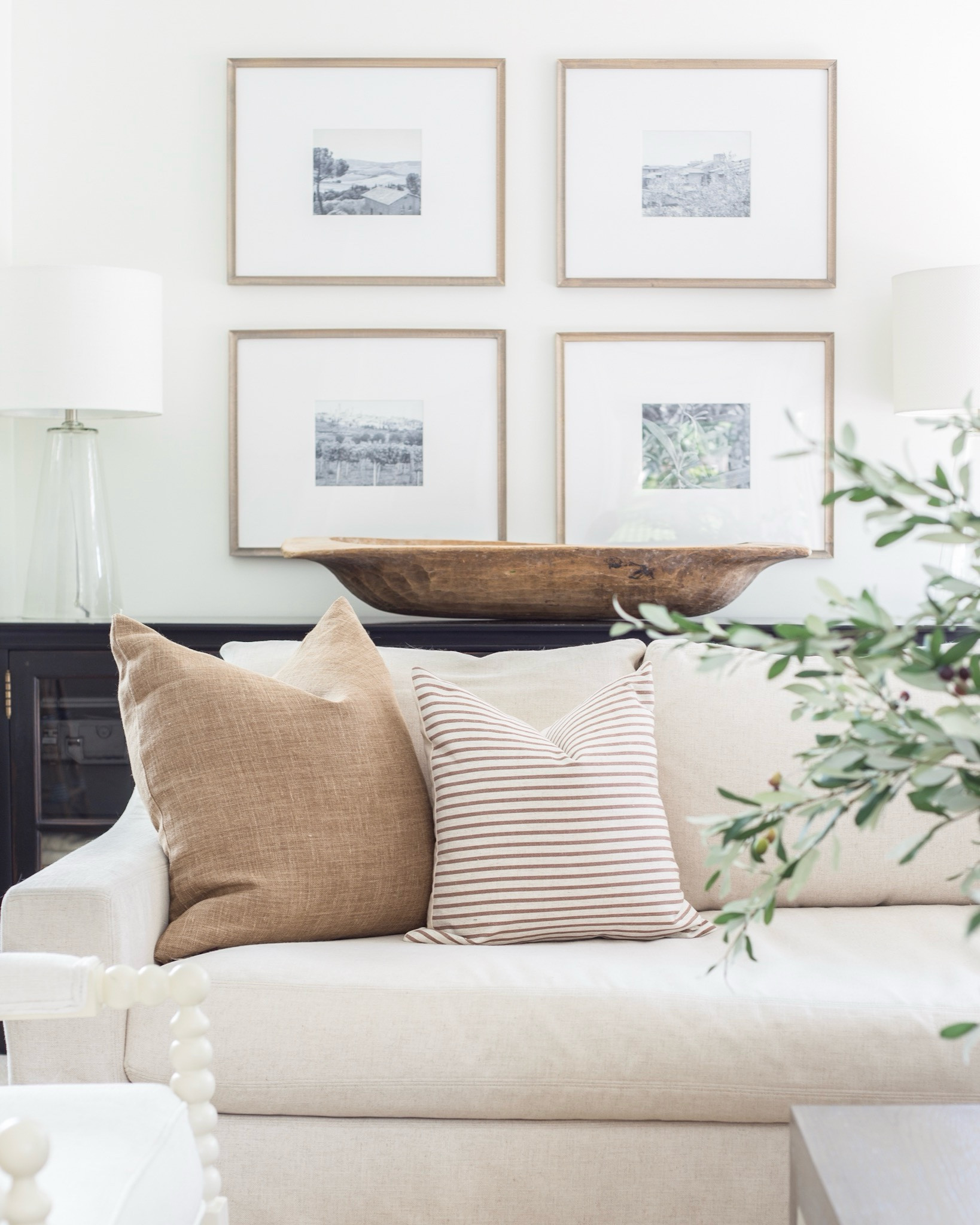 The coziest neutral decor for fall! Loving the neutral, green, and white fall decor in our Omaha living room! 🍂 Includes a linen slipcover sofa, large wood dough bowl, glass lamps, vase full of olive stems, brown striped pillows, gallery wall, and more fall decor. And many of these items are on sale right now!

#LTKhome #LTKsalealert  #ltkfindsunder50 #ltkfindsunder100 #ltkstyletip #ltkseasonal fall decor, leather poufs, fall throw pillows, living room decor, family room, olive greenery, faux greenery, picture frames.

#LTKSeasonal #LTKHome #LTKSaleAlert