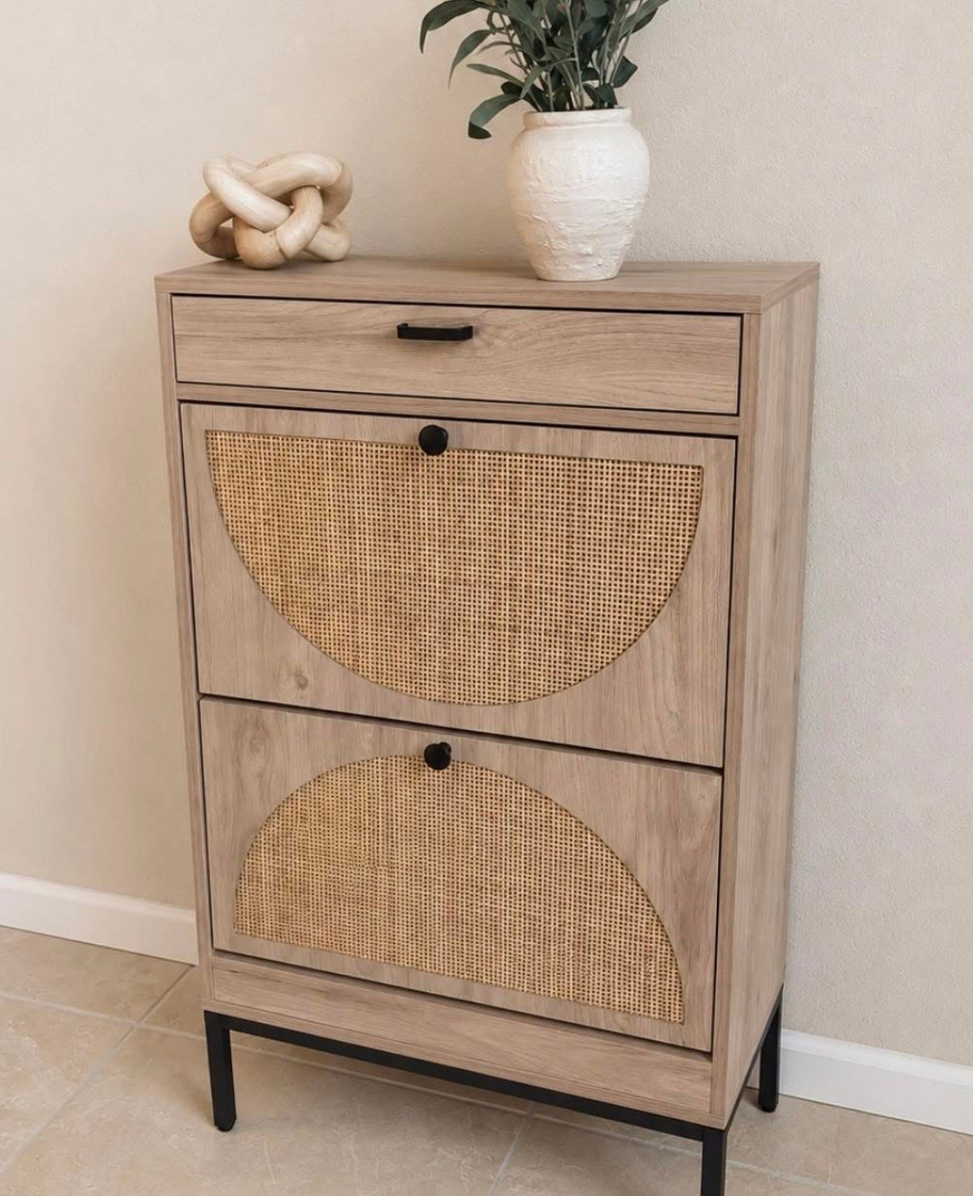 ✨ this $85 shoe cabinet honestly looks SO much more expensive in person

I’ve been wanting something that hid shoes without looking bulky or overly “storage looking” and this one gives such a Studio McGee / designer look for less vibe 🙌

it’s over 50% OFF right now 

✔ hidden storage for up to 12 pairs of shoes  
✔ slim profile for small entryways or narrow spaces  
✔ beautiful cane detail doors  
✔ top drawer storage  
✔ warm neutral wood tones + black accents

I styled mine with a vase + greenery on top and it instantly made the whole area feel more elevated without taking up much space 🤍

I’ll also link more favorite sale finds from the brand above ✨

#LTKMothersDay #LTKmomlife #LTKmorningroutine