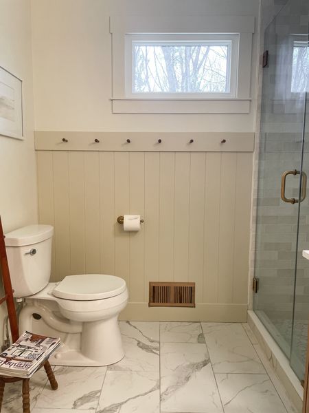 Master bathroom accent wall completes the space and gives it character.  

Shiplap panel.  Kohler toilet.  12 X 24 ceramic porcelain floor tile.  White oak vent cover.  Antique brass toilet paper holder.  Mission pegs.  Home Depot shower door.  

#LTKfamily #LTKstyletip #LTKhome