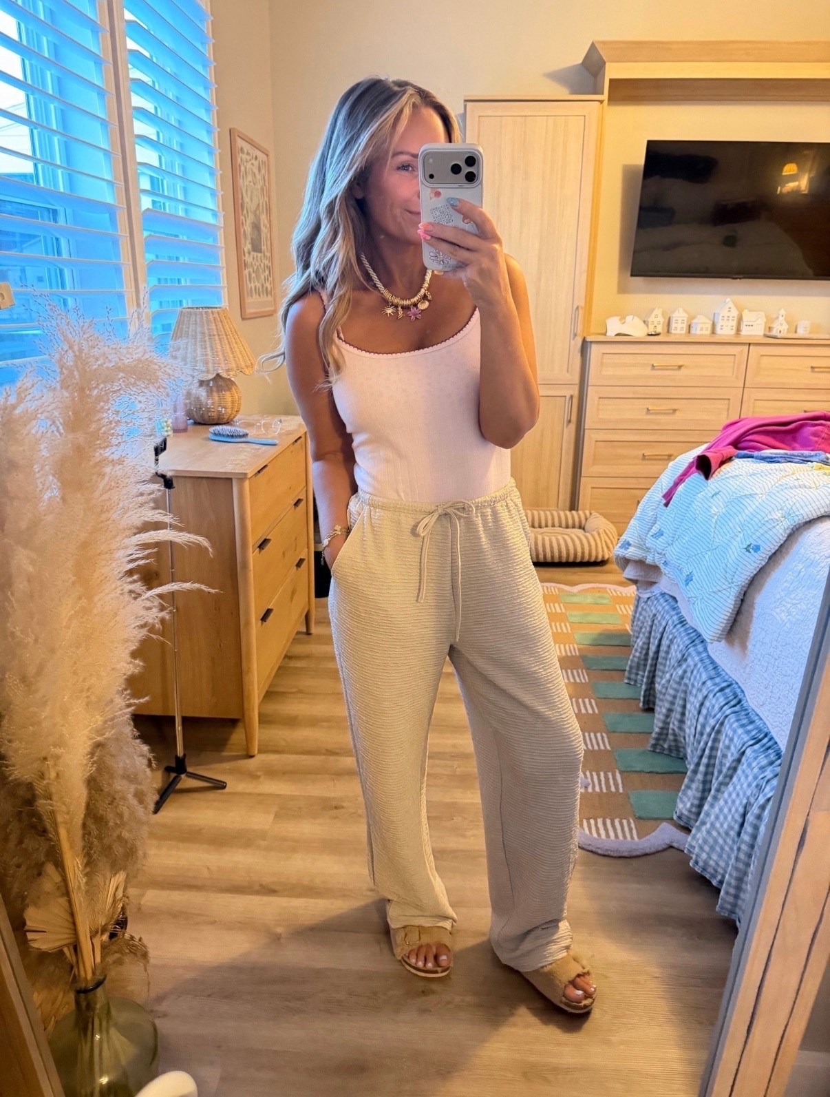 This is one of those outfits that feels like pajamas but looks so much more put together. ☁️🤍 These textured drawstring pants are lightweight, super flattering, and perfect for everything from travel days to brunch to running errands. Paired with a simple pink tank and comfy slides for an easy summer look you’ll reach for on repeat.

Comment LINK and I’ll send you all the outfit details! ✨