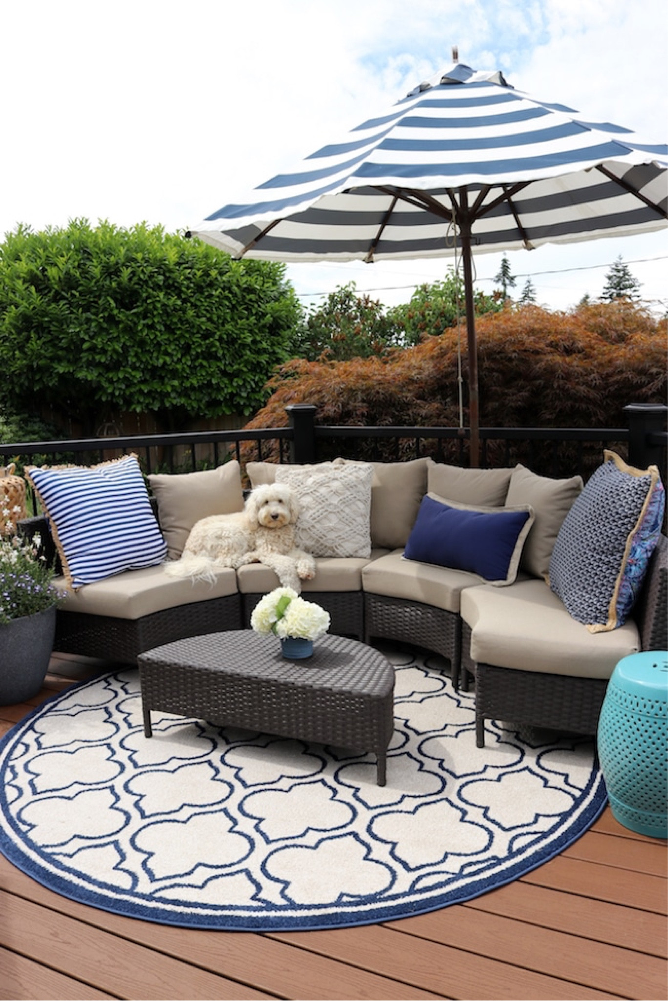Similar curved outdoor wicker sofa, blue and white stripe umbrella, aqua garden stool, round blue and white patterned rug 

#LTKsalealert #LTKhome #LTKSeasonal