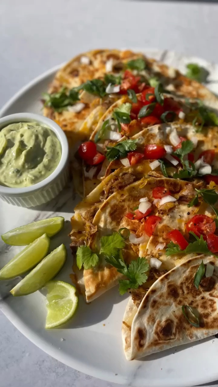SLOW COOKER PULLED PORK QUESADILLAS. The last time I prepped pulled pork I made three different meals out of it. These quesadillas were a huge hit with the family. 🔥

INGREDIENTS 
Olive oil 
Pulled pork (pork shoulder slow cooked in crockpot with olive oil, salt, cracked pepper, smoked paprika, brown sugar, bbq sauce, garlic, white onions on high for 5-6 hours or low for 8-10 hours)
White onions, halved and sliced 
Tortillas 
White cheddar, shredded 
Mexican Four Cheese shredded blend 
Toppings: creamy avocado cilantro lime sauce (Greek yogurt, avocado, cilantro, lime juice, cracked pepper), diced white onions, diced tomatoes, cilantro, jalapeños and lime wedges

TO MAKE: add olive oil to a large pan on medium-high heat. Add onions, sauté for 3-4 minutes. Add pre-cooked chopped pulled pork. Cook until lightly browned. About 5-6 minutes. Set aside. 

Using the same pan, on medium heat, add butter and a flour tortilla. On one side of the tortilla sprinkle on white sharp cheddar cheese, followed by pork and then a layer of Mexican shredded cheese. Fold empty side over. Cook one minute then flip. Cook another minute. 

Serve with creamy avocado cilantro lime sauce, diced white onions, diced tomatoes , cilantro, jalapeños and lime wedges 

#crockpots #potsandpans #servingplatters #platters 

#LTKkids #LTKfamily #LTKunder50
