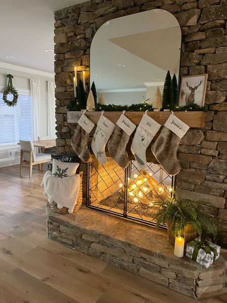 Christmas home decor in the living room. Stockings, garland, Christmas lights, candles, wreath, mirror, basket, throw blanket, pillows, Christmas trees

#LTKhome #LTKHoliday #LTKsalealert