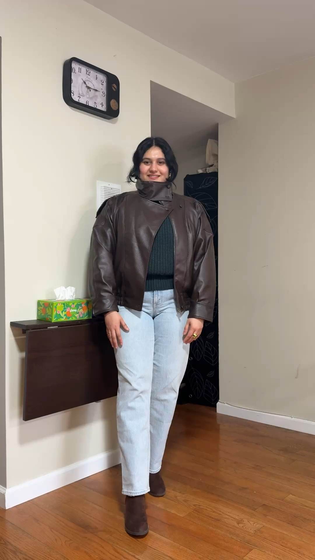 Dark brown leather jacket with a funnel neck or turtleneck collar, dark green sweater, light wash jeans, and brown boots  

#LTKootd #LTKSeasonal #LTKMidsize