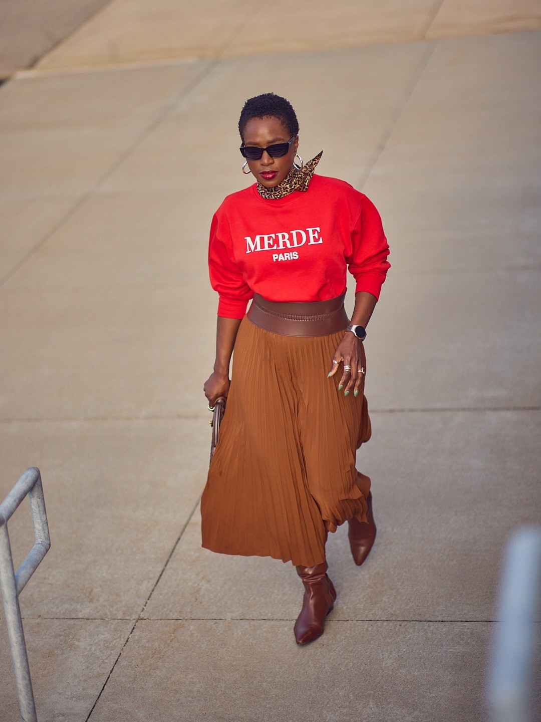 Achieve instant edge with a graphic sweatshirt! Love this red one paired with a brown pleated skirt for Fall | Fall 2025, New York Fashion Week outfits, brown tones, Revolve, Reiss, tall boots

#LTKstyletip #LTKover40 #LTKSeasonal