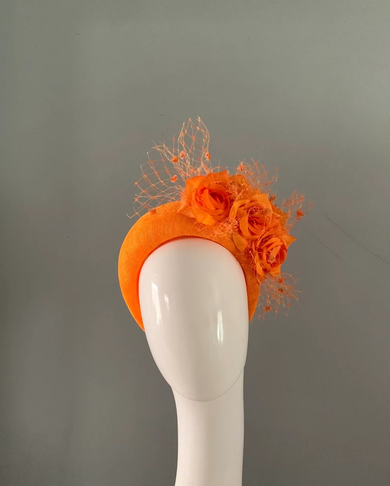 Tangerine crown perching hat fascinator adorned with silken flowers and merry widow veiling. | Etsy (US)