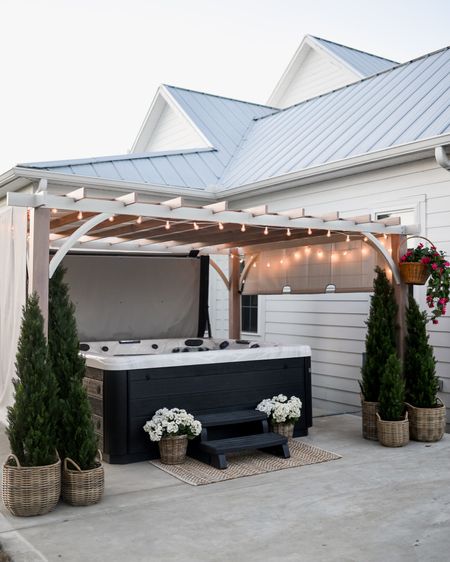 Patio hot tub with pergola gazebo. Outdoor string lights command hooks cedar trees baskets flowers hanging plant jute scatter rug poolside patio outdoor furniture modern farmhouse style transitional classic decor style accessories and home accents 

#LTKFind #LTKSeasonal #LTKhome