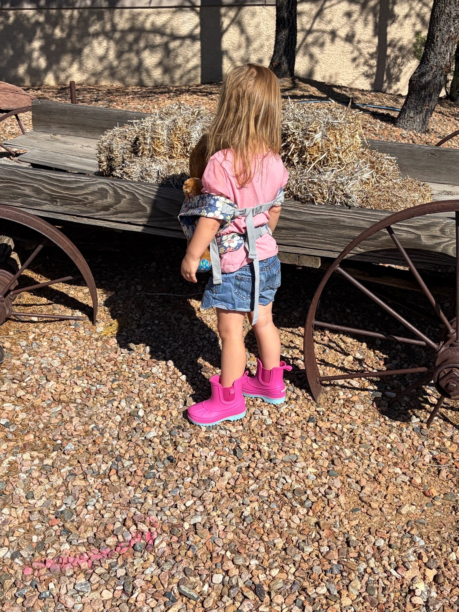 Toddler outside walking with a baby carrier and rain boots

#LTKKids #LTKdayinmylife