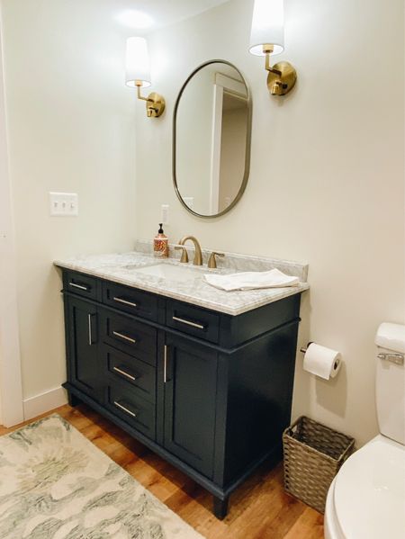 Navy bathroom vanity with oval mirror and gold sconces 

#LTKfamily #LTKfindsunder100 #LTKhome