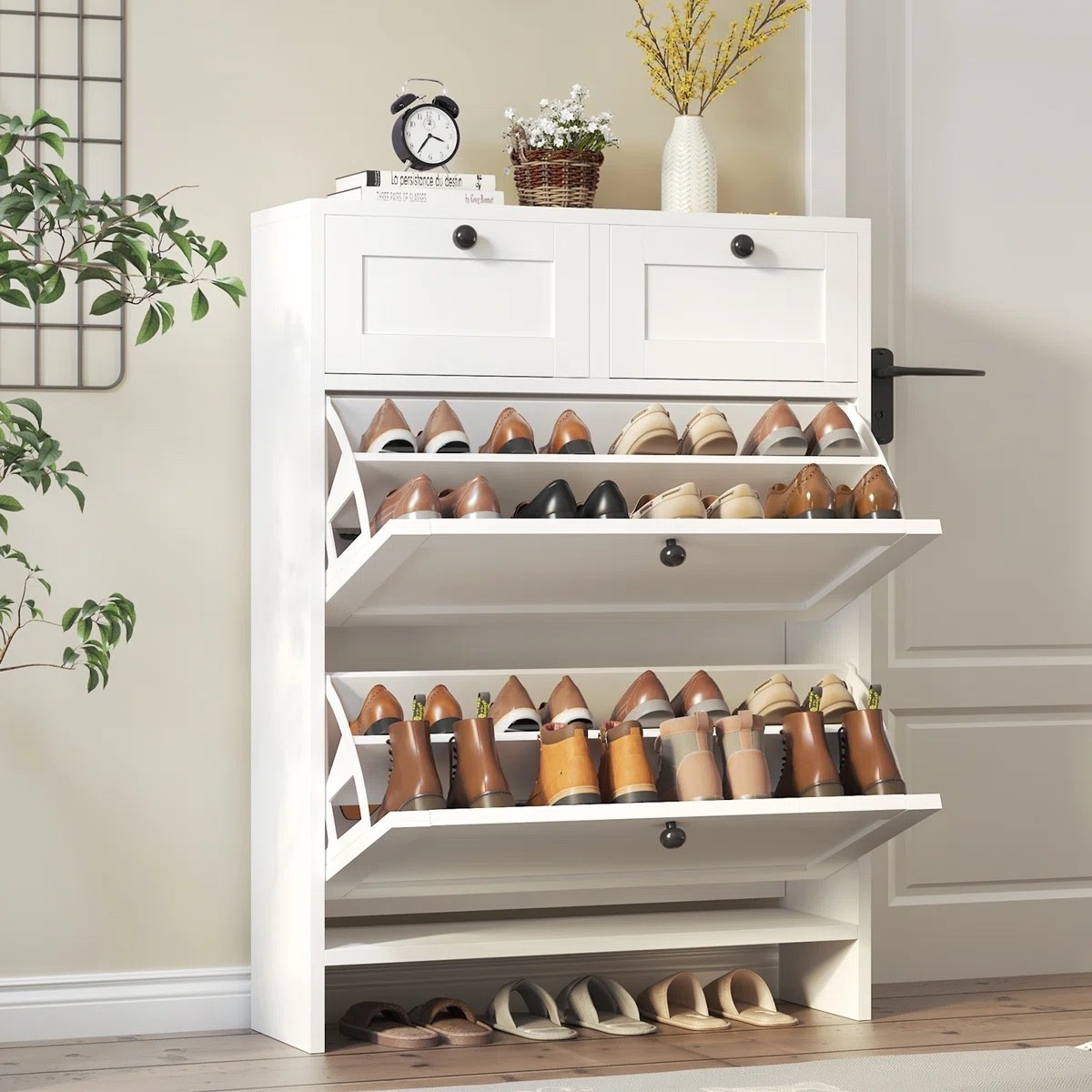 This white shoe storage cabinet from Wayfair is such a nice solution when you want the entryway to feel tidy without a big open shoe rack on display. It holds up to 16 pairs, with two flip-down shoe compartments plus two top drawers for smaller everyday things. I also like that the surface gives you room for a little clock, greenery, or a vase so it still feels like part of the room. It’s currently shown at $129.99 and marked on sale.