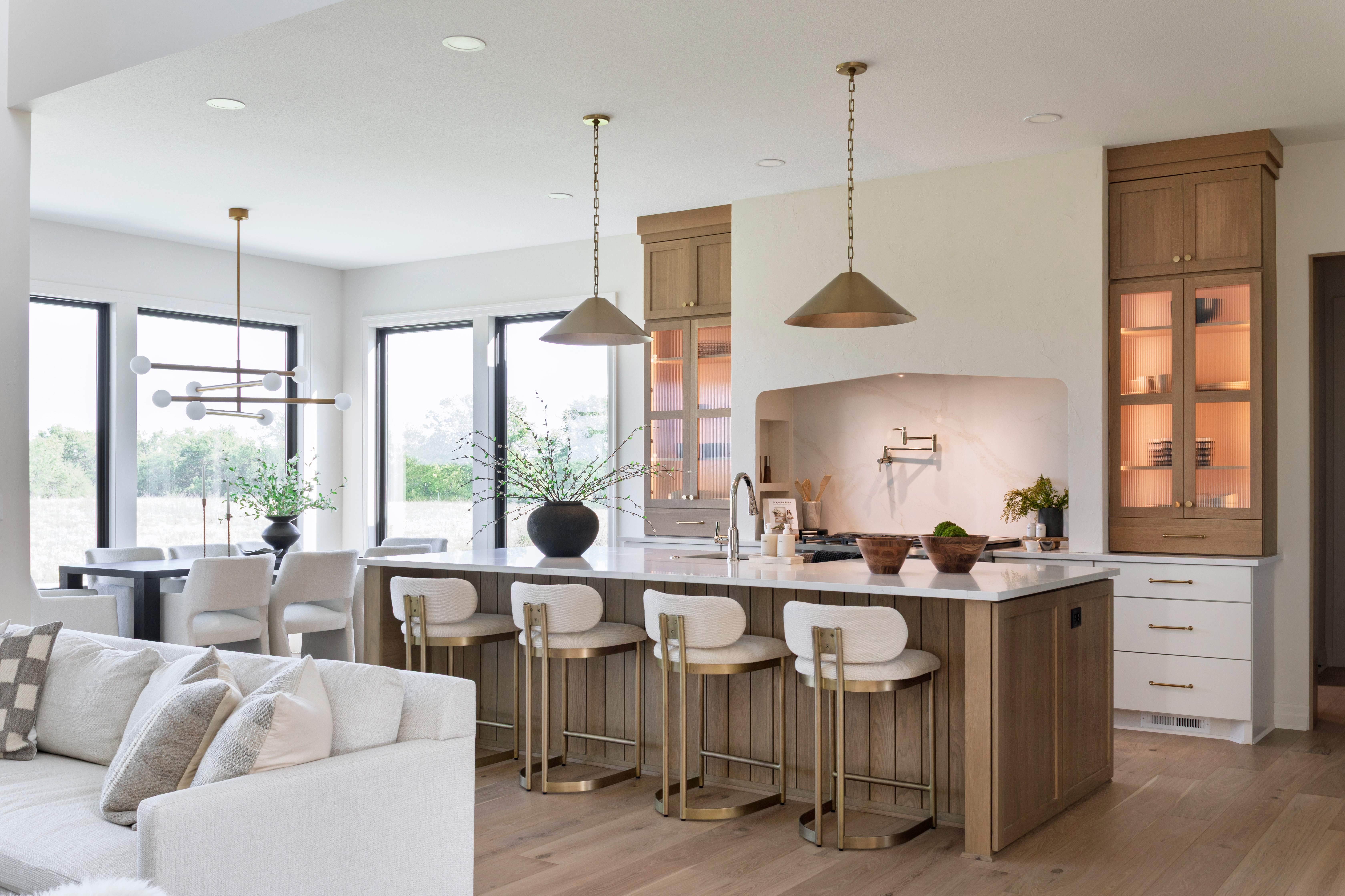 Every piece in this space is handpicked to bring warmth, texture, and sophistication to everyday living. The upholstered bar stools feature a curved back and brass frame—comfortable, timeless, and the perfect blend of form and function. The brass kitchen pendants are statement makers, adding a soft glow and modern contrast against the natural wood cabinetry and marble backsplash.

We styled the island with ceramic vases, wooden bowls, and neutral kitchen accessories to create an inviting, lived-in look that’s still elevated. The adjoining dining space ties it all together with a modern chandelier, upholstered dining chairs, and a solid wood table—each piece carefully chosen to complement the organic tones of the kitchen.

Shop the look below to recreate this warm modern kitchen and dining space in your own home.

#LTKhome #LTKkitchen #LTKhomefinds #kitchendecor #kitchenfurniture #barstools #counterstools #brasspendants #modernlighting #kitchenpendantlights #kitchenislanddecor #diningroomdecor #diningroomfurniture #diningroomlighting #diningroomchandelier #neutralhomedecor #organicluxuryliving #modernhome #LTKshop #shopthislook 

 #LTKHome #LTKStyleTip #LTKFamily