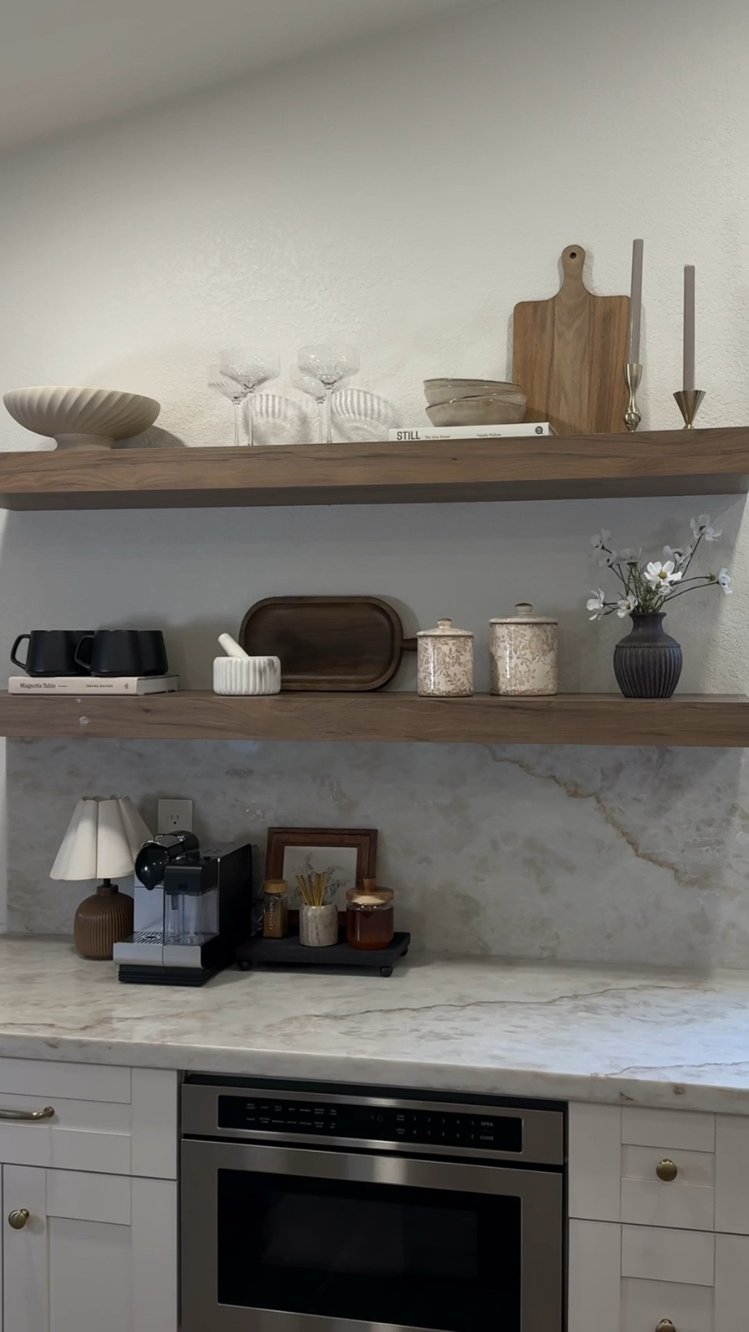 Kitchen shelf styling inspo! I’ve finally perfected my kitchen floating shelves 😍 
•
Kitchen decor, shelf decor, floating shelf, kitchen shelf, neutral home, neutral kitchen, wood tone kitchen, Taj Mahal kitchen, cutting boards, coupe glasses, footed bowl, pedestal bowl, ceramic bowls, glazed bowls, stoneware bowls, champagne bronze, candle holders, taper holders, black mugs, pestle and mortar, canisters, magnolia home, spring flowers, spring stems, daisy stems 


#LTKHome #LTKSeasonal #LTKFindsUnder100