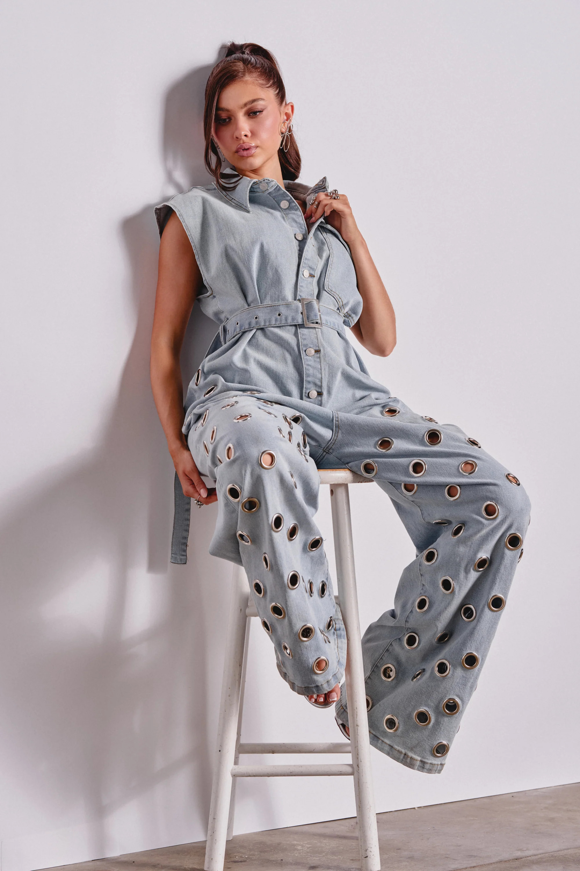 PLAY YOUR CARDS RIGHT DENIM JUMPSUIT WITH GROMMETS IN LIGHT WASH | AKIRA