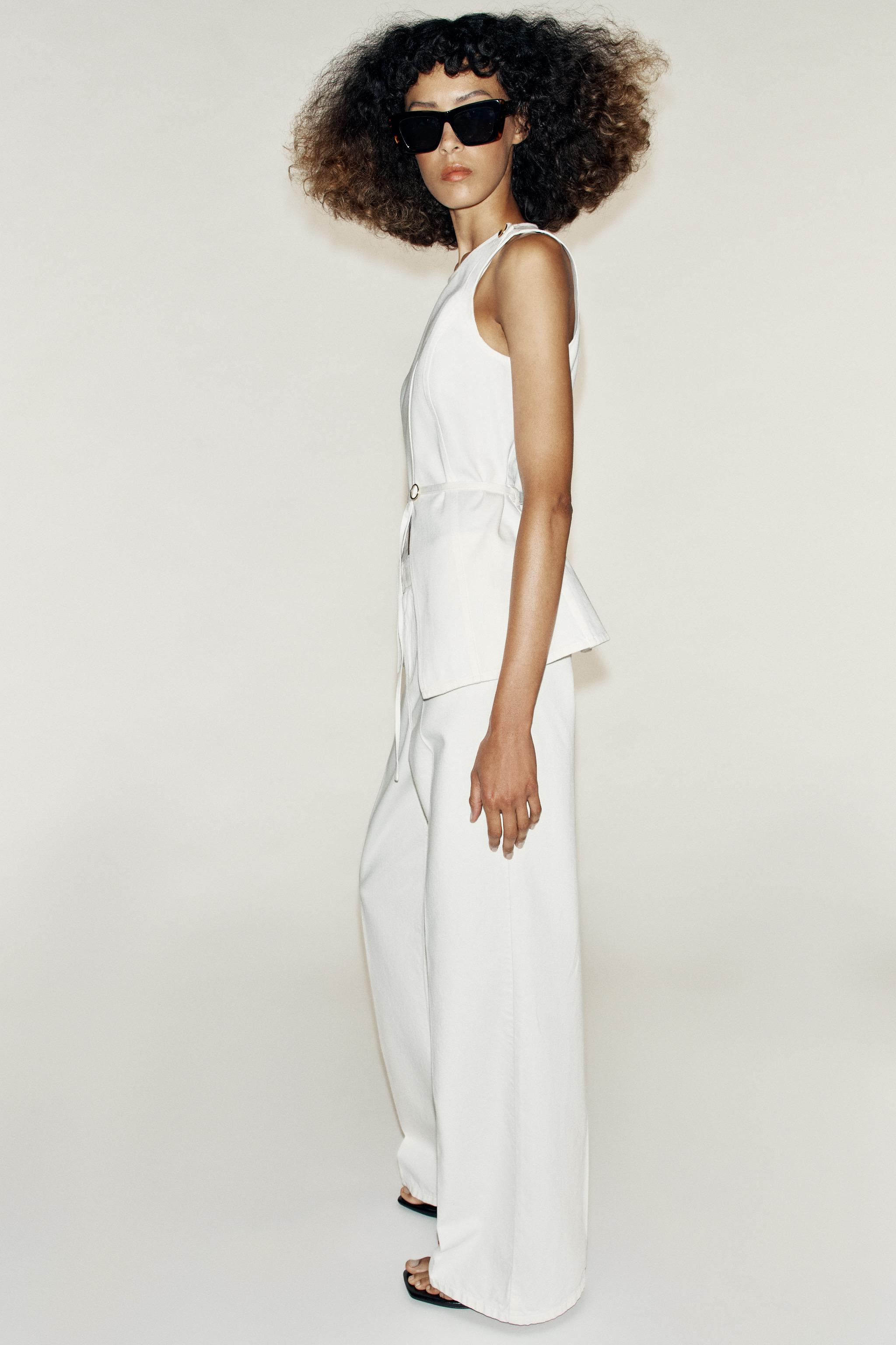 Round neck sleeveless waistcoat. Featuring a slim belt with a buckle and a double-breasted button... | Zara UK