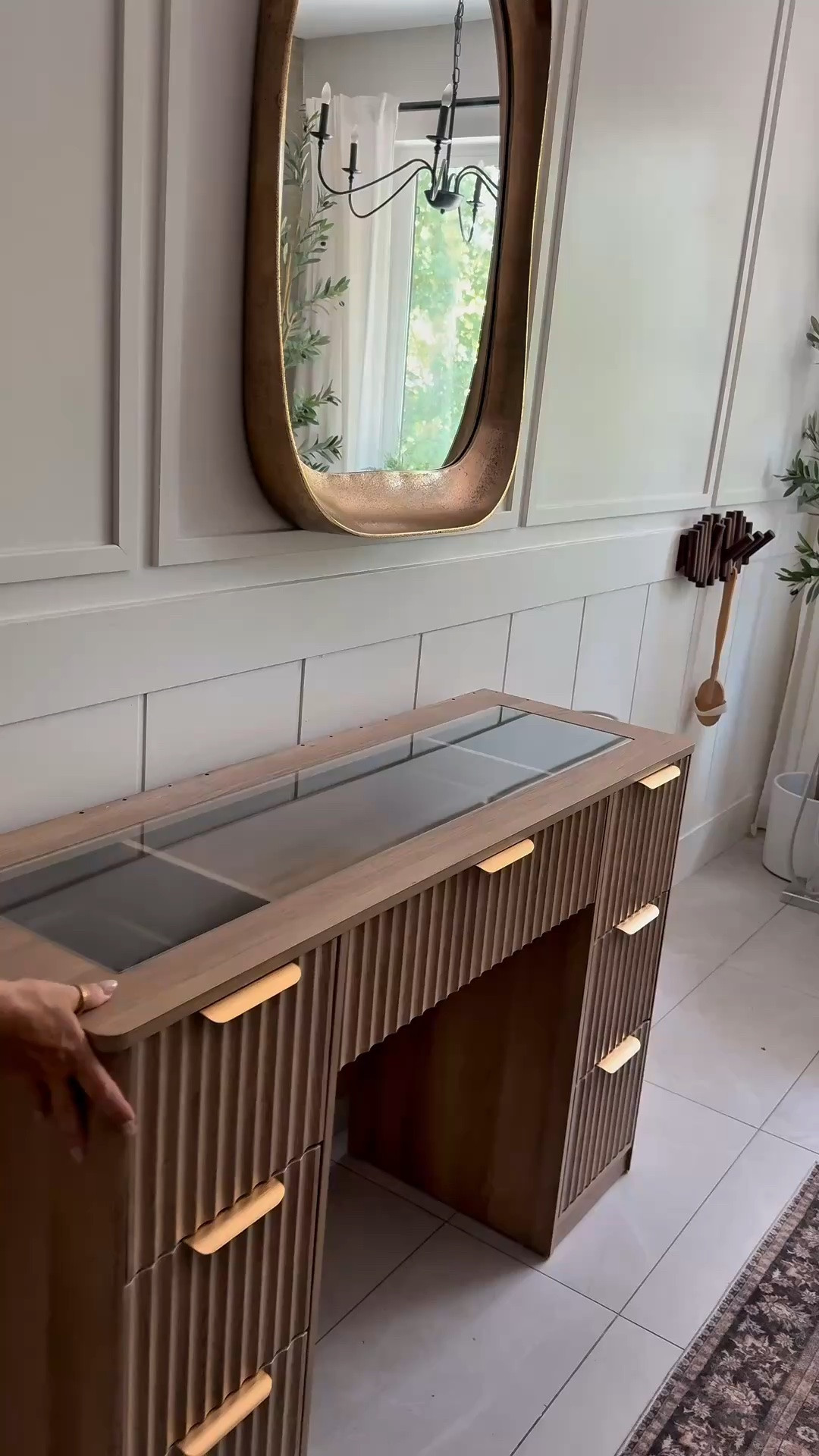 New makeup vanity for the bathroom! . Gorgeous wood tone and so much storage! 
I decided to not use the mirror that comes with the vanity. Love the organic  look of this brass arch mirror! 
 Bathroom vanity