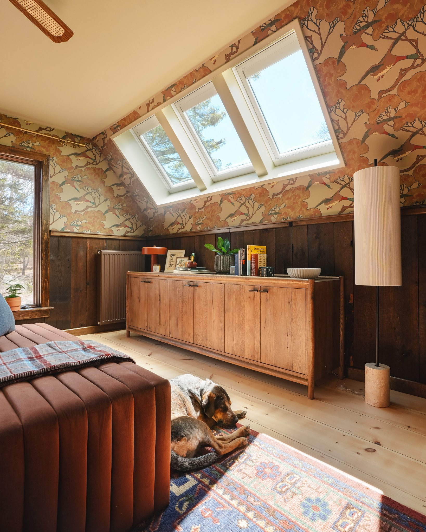 The ✨ details ✨For our primary bedroom renovation, our design plans prioritized maintaining the cabin charm, but adding the mid-century modern, retro vibe that the rest of the cabin has. We started by refinishing the existing hardwood floors and then we repurposed the wood paneling on the slanted ceilings and reinstalled it on the lower portion of the walls throughout the room. The duck wallpaper is definitely the focal point of the room and we added a few vintage furniture pieces with modern design elements to create a cohesive, balanced interior. Natural materials, bold colors combined with earthy tones, and soft lighting from several lamps complete the space. Check out more of the room on our blog! 

 #LTKHome #LTKSaleAlert