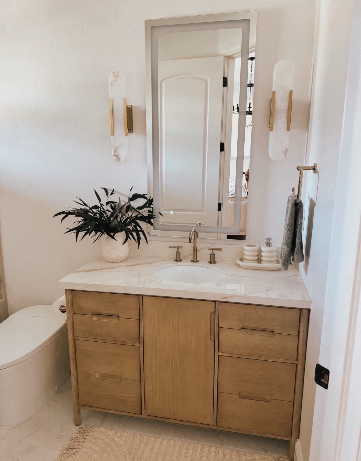 Love this bathroom vanity that comes with the marble top. The melange sconces are a show stopper plus the gold faucet and fixtures in this bathroom remodel 



#LTKU #LTKHome