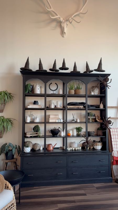 So many of my favorite indoor Halloween decor pieces in one room! 🎃

Besides our 12ft skeleton, the wicker witch hats from @mcgeeandco are my absolute favorite purchase of 2022. I ordered one set, they arrived, and I had a vision of them floating atop our Magnolia hutch. 🤩

Three additional wicker witch hat sets, and many weeks of not so patiently waiting later, and here we finally are!!

Other favorites this year include the @potterybarn jack o lantern pillow, my collection of @molliejenkinspottery tea light ghosts, and the grapevine spiders from @grandinroad that I found from @birchlaneinteriors! 

Linking everything I can over on @shop.ltk! 

#mcgeeandco #studiomcgee @studiomcgee #studiomcgeehalloween #mcgeeandcoinspired #wickerwitchhats 

#LTKSeasonal #LTKHalloween #LTKhome