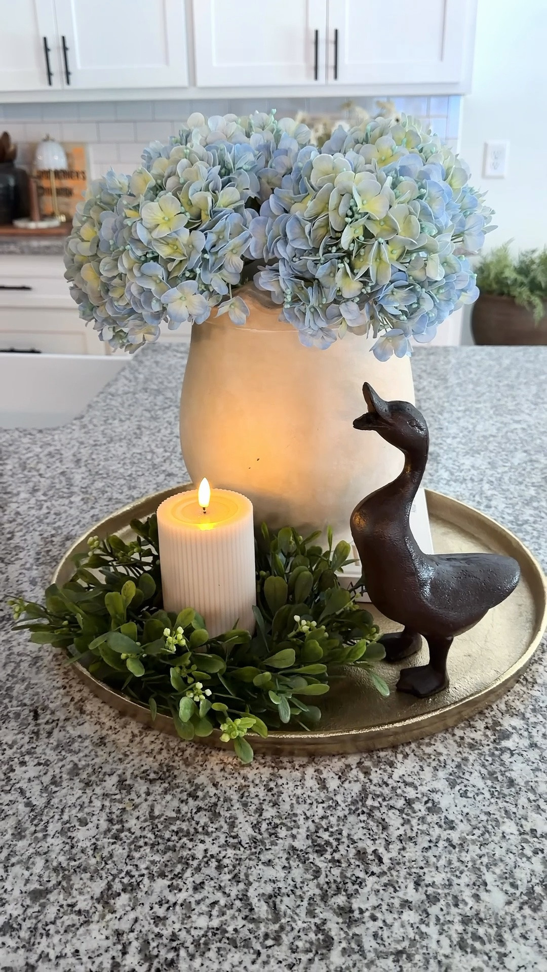 The gorgeous blue-green hydrangeas, the sweetest little duck, and a candle ring paired with a flameless candle all come together for the prettiest Summer look. I love how the soft colors and layered textures make this feel both cozy and elegant while still being simple enough to recreate in your own home. This is the kind of styling that can carry you beautifully all season long.