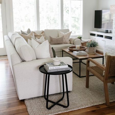 In my living room I have the Pottery Barn Pearce sectional and chunky wool jute rug. Nest to the sofa is a black side table topped with books  

#LTKstyletip #LTKFind #LTKhome