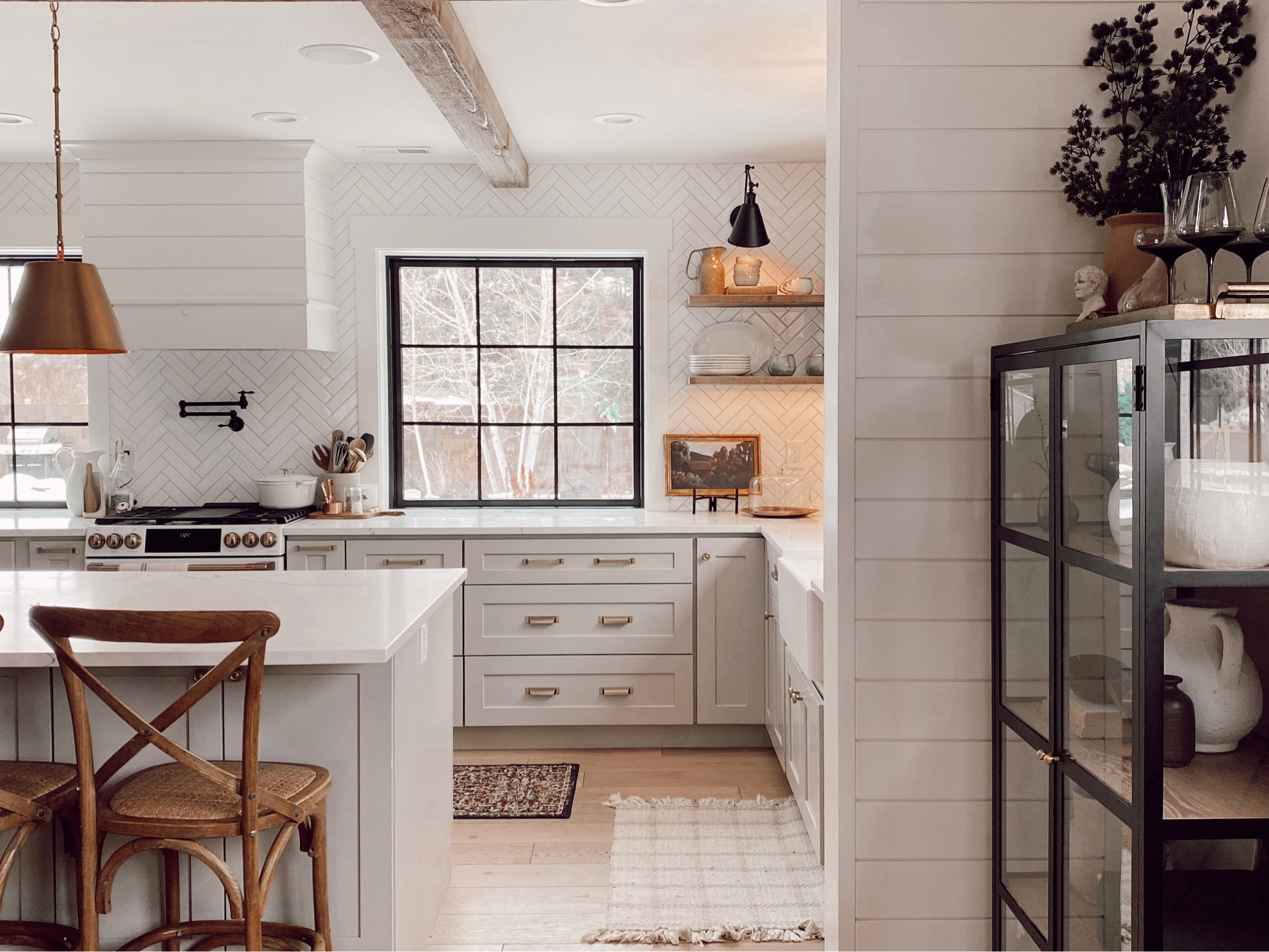 Winter Kitchen | gray cabinets, brass hardware, white range, cafe range, black cabinet, wood counter stools, open shelving, vintage art, brass pendant lights, swing arm wall sconces, dark rug runner

#LTKSeasonal #LTKhome #LTKsalealert