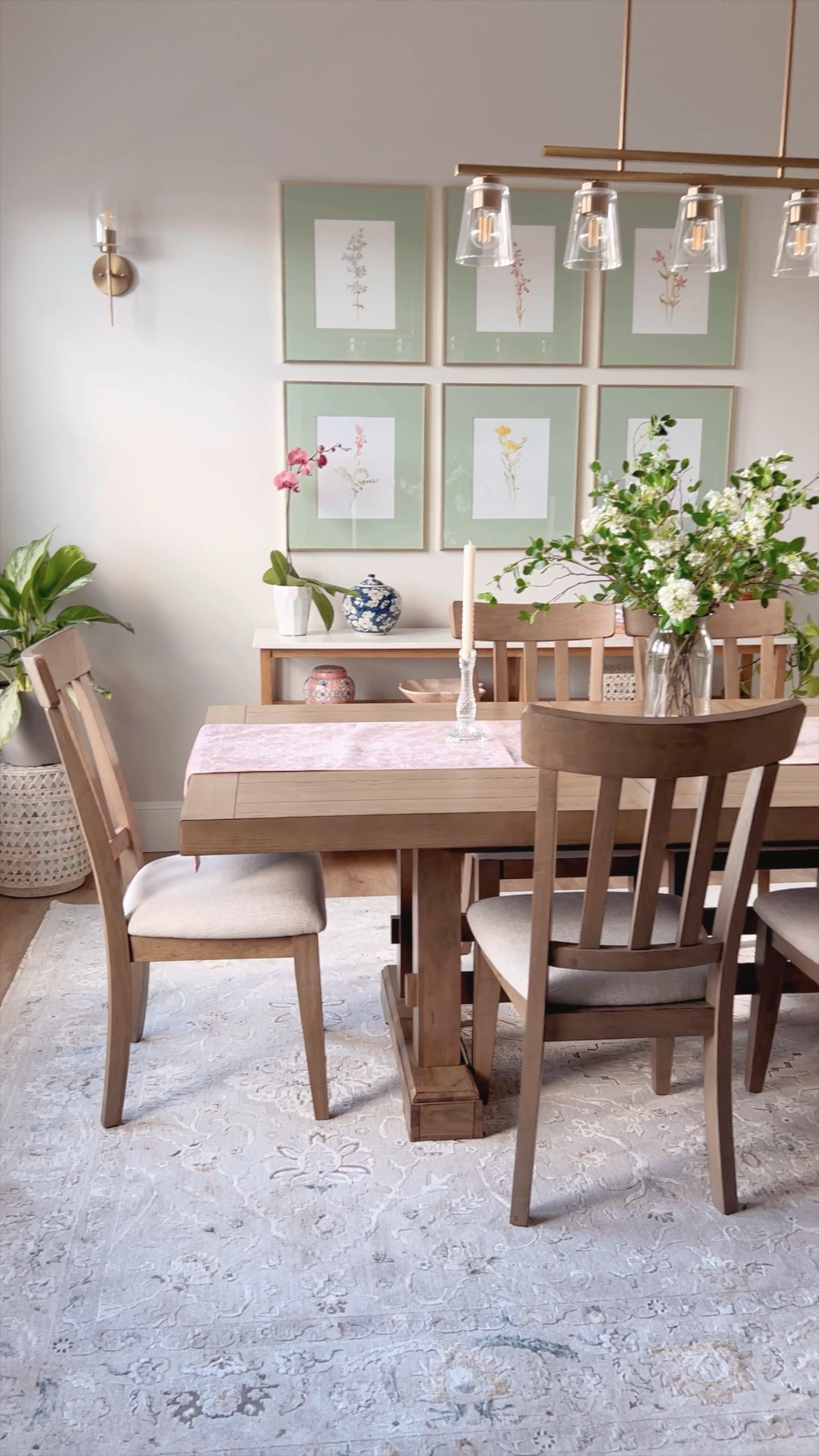 Nature inspired dining room design for my client. I love how the floral gallery wall frames turned out with the mats I custom painted green!

Gold frames with mat, rug, dining room table and chairs, dining room console, jasmine faux floral stems, green floral stems, floral vase, pink table runner, twisted taper candles, glass candlestick holders, grandmillenial, French country, traditional, vintage water color art reproduction  