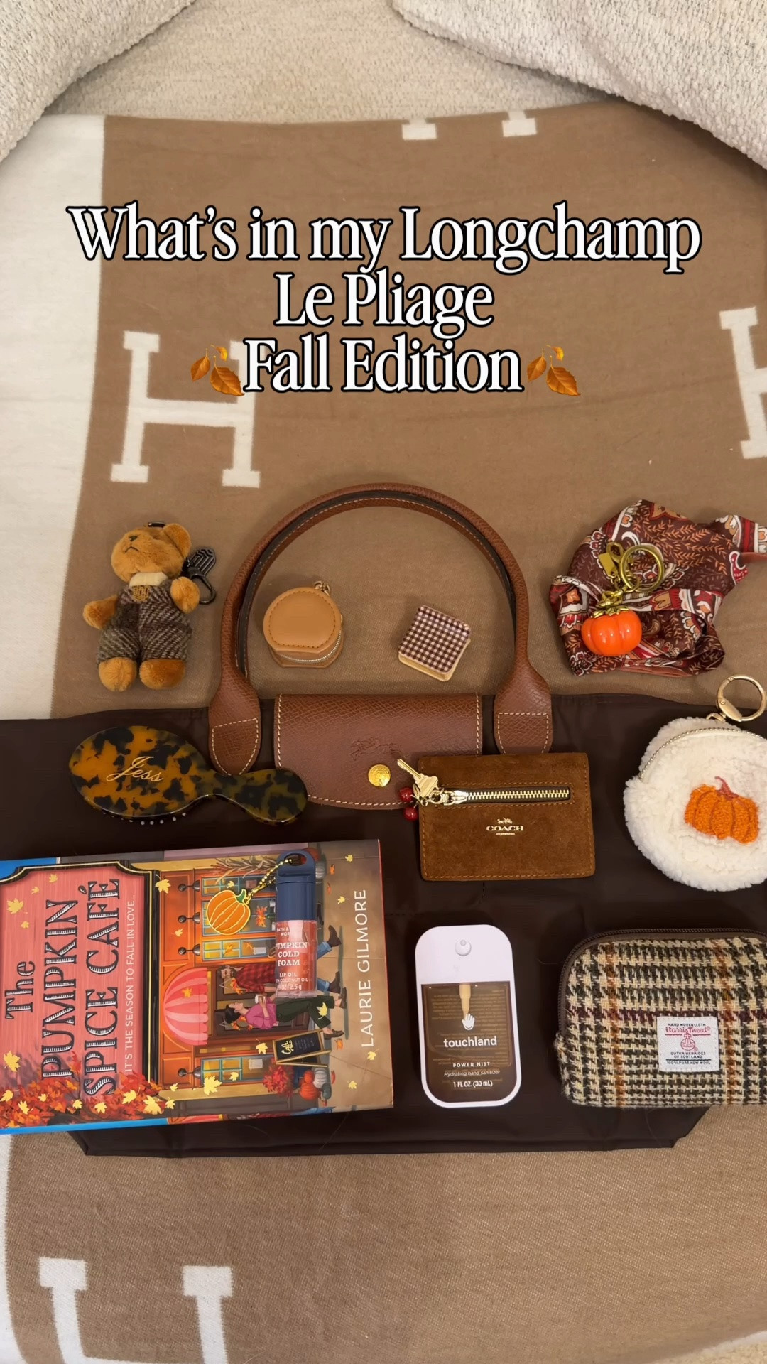 What’s in my bag 🍁 Comment SHOP & I’ll dm you the links 🍂

What fits in the large longchamp Le Pliage handbag:

Pumpkin spice cafe book 🍂
Reusable sticky lint roller ball
Harris tweed pouch
Suede coach outlet wallet 
Custom mini hairbrush from Etsy
YSL mini blush
Guerlain lipstick
Rare beauty mini blush 
Clear makeup pouch
Mini makeup bag with removable light up mirror
Touch land hand sanitizer
Mini jewelry holding pouch
Pumpkin bag charm
Mini wet wipes
Kayali mini perfume
Athena body spray charm
Flexible claw clip