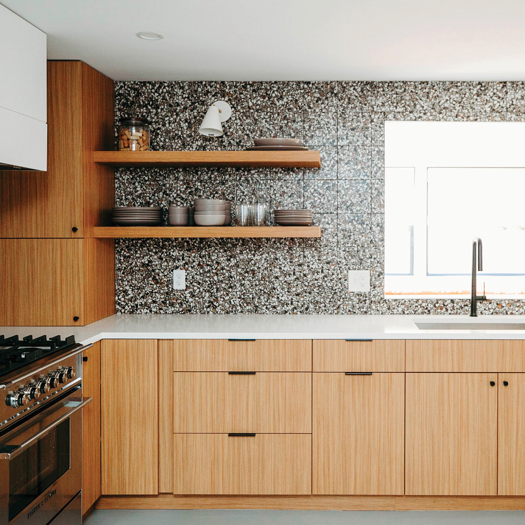 inspired by the original design, #dwelloctoberstudio reimagined this kitchen for modern life, using warm wood cabinets to capture the mid-century feel. we converted the window above the sink to a simple opening to bring light in from the sunroom, replaced the old linoleum with sleek gray epoxy flooring, and added a fun terrazzo-inspired statement tile backsplash. #dwelloctoberrealestate #dwelloctober

#LTKhome #LTKfindsunder50