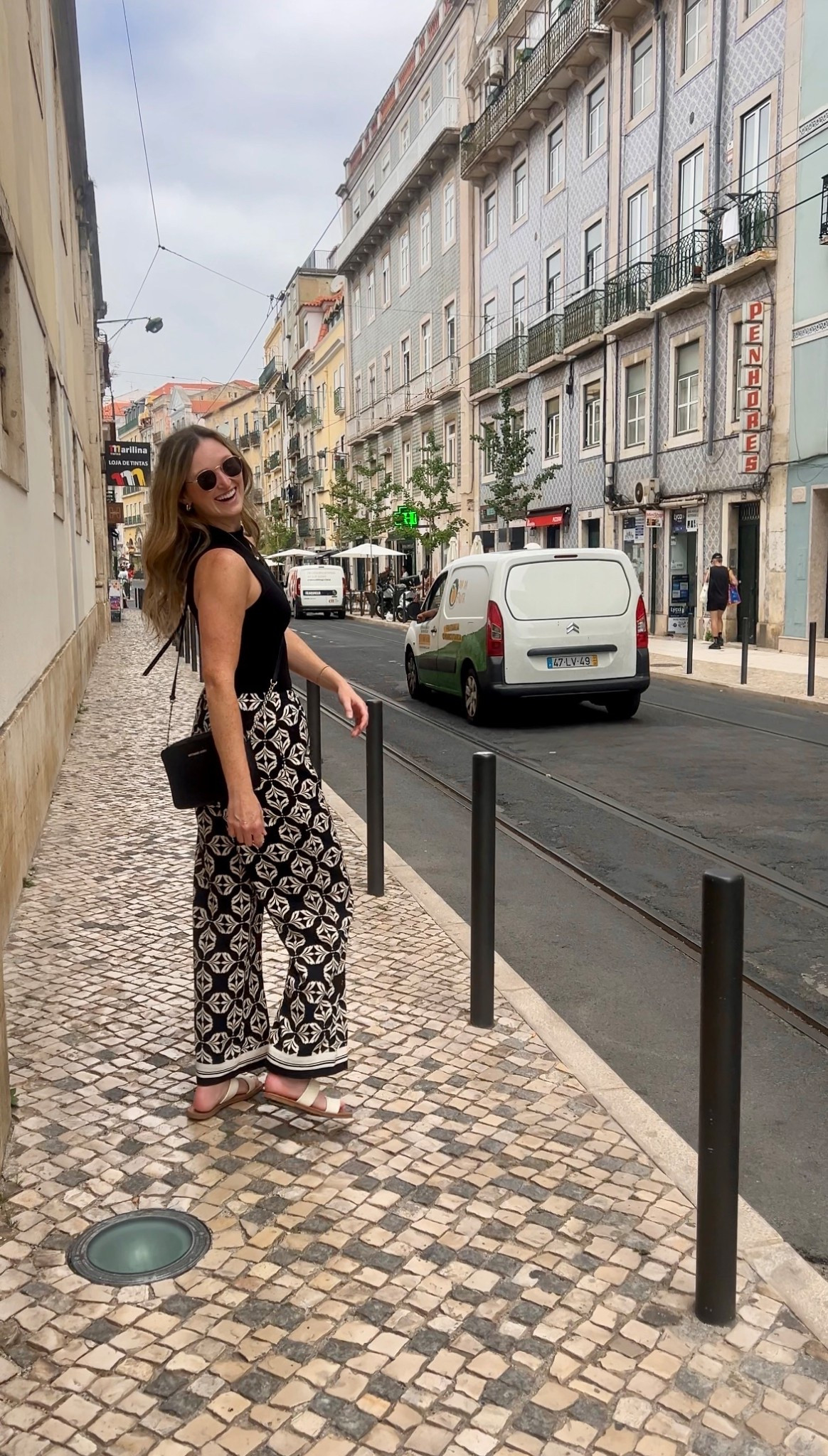 Casual Europe vacation outfit. Comfortable summer travel outfit. Tall girl friendly printed pants (wearing M Tall), high neck black tank, black cross body bag, white sandals 

#LTKTravel #LTKSeasonal